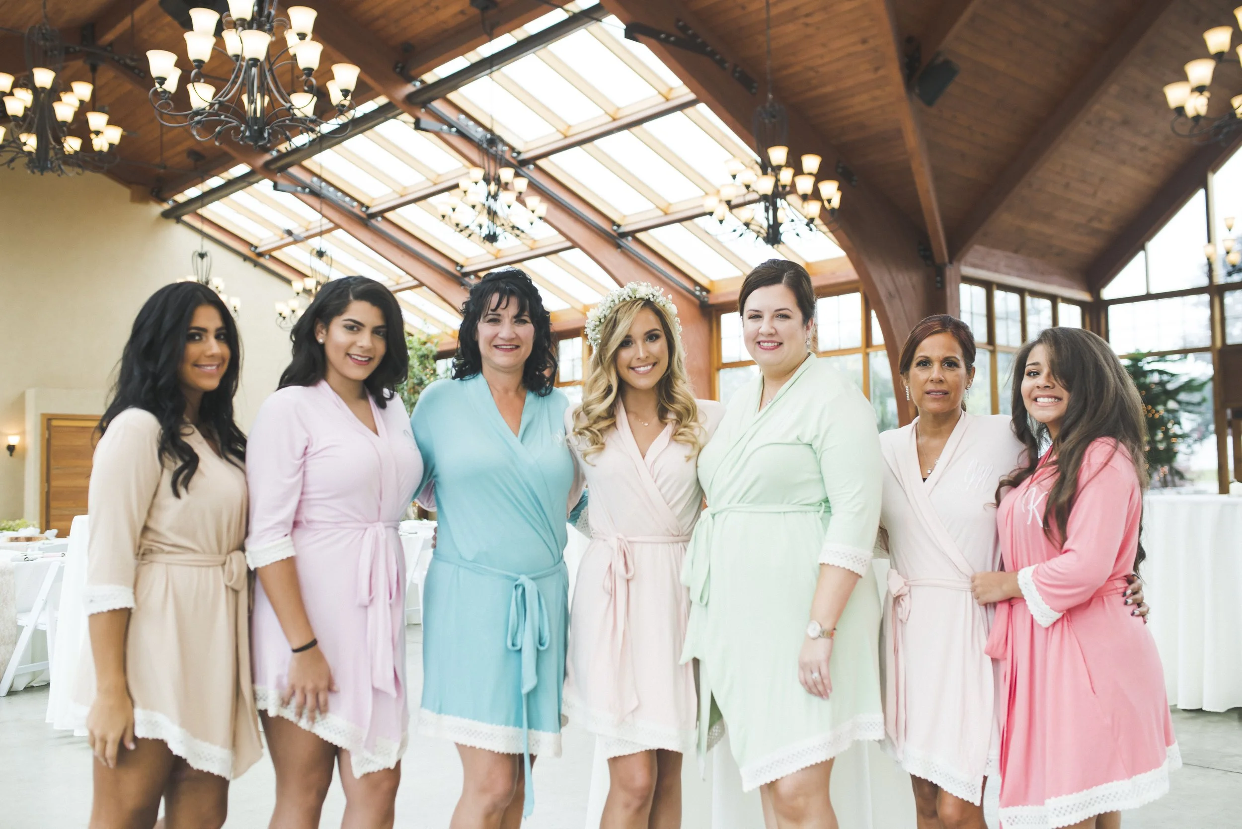 A group of women in matching robes smiles together for a photo, showcasing their unity and friendship.