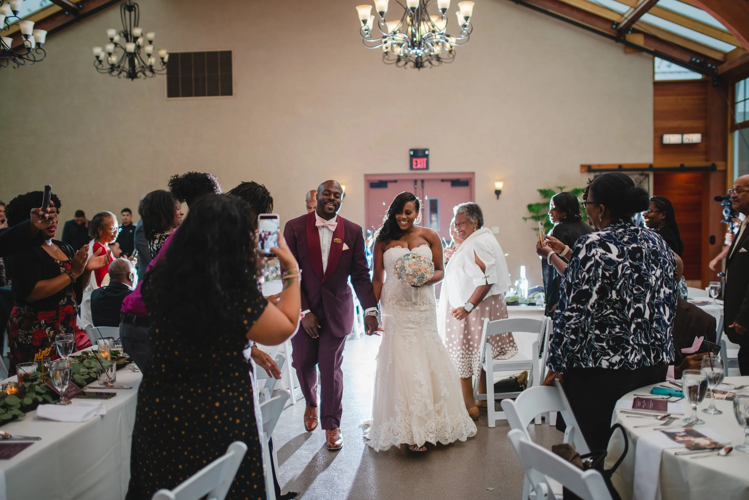 A bride and groom joyfully walk down the aisle together at their wedding ceremony, surrounded by floral decorations.