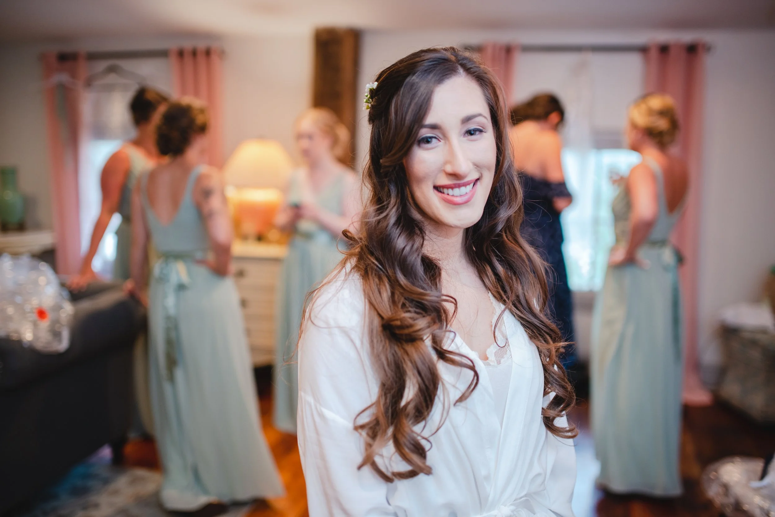A smiling bride in her wedding attire, joyfully preparing for her special day.