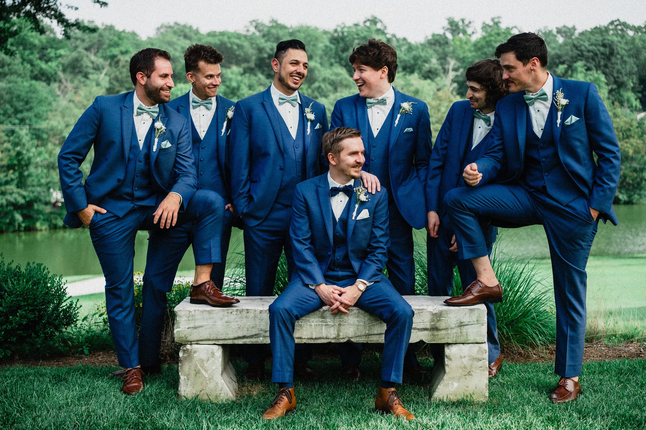 A group of men in blue suits smiling and posing together for a formal photo.