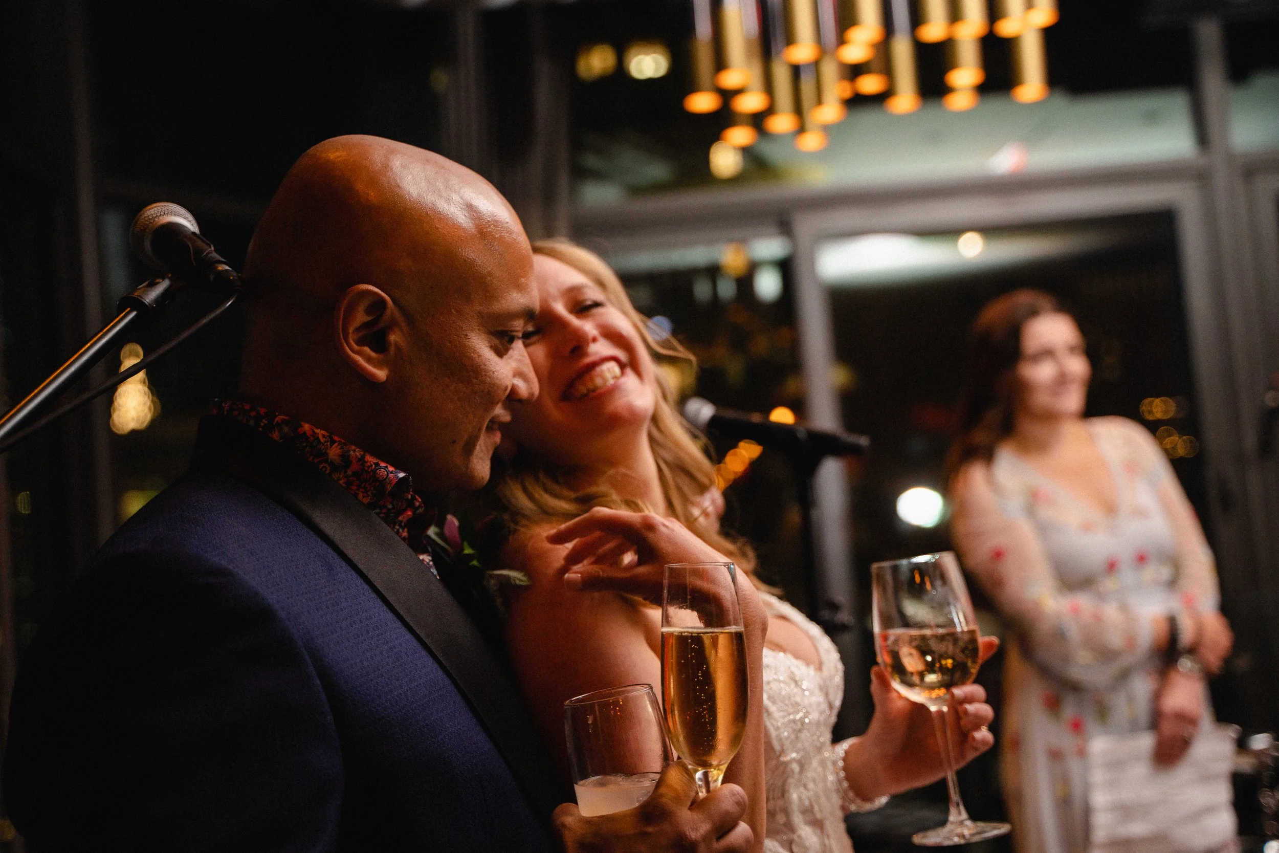 A joyful bride and groom toast their guests, sharing laughter and celebration on their wedding day.