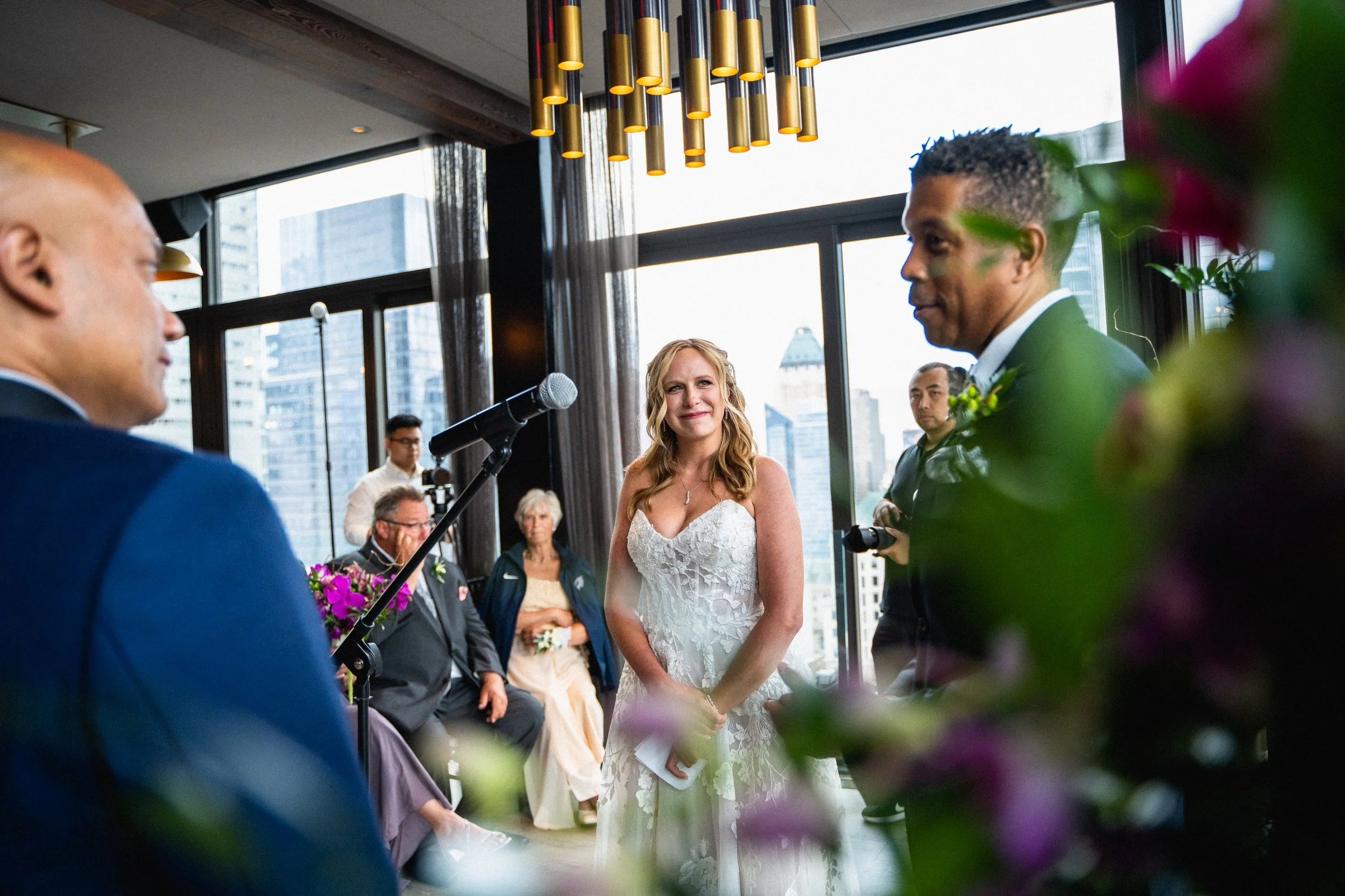 A professional wedding photographer capturing a couple in a romantic pose against a Chicago skyline backdrop.