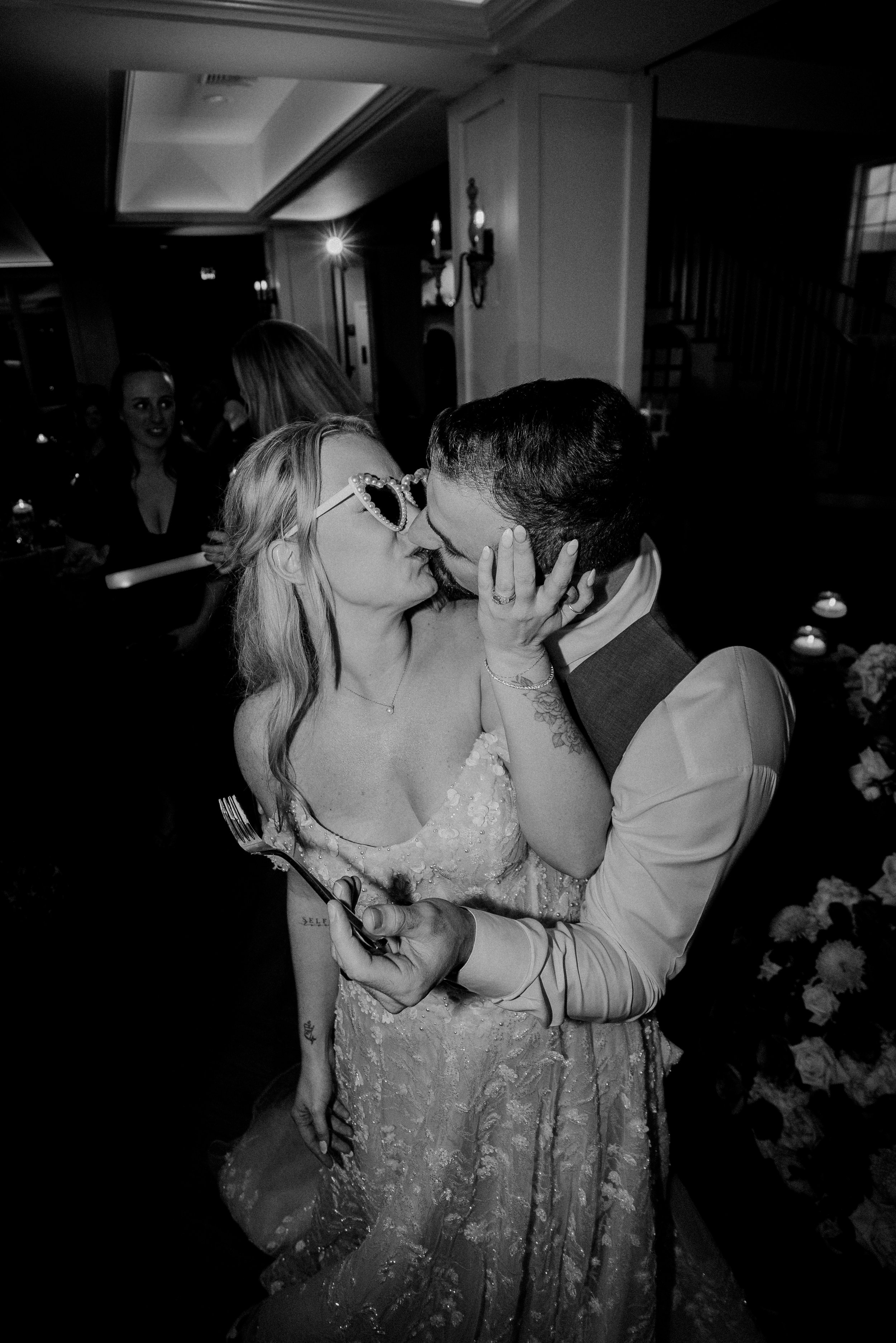NJ wedding photography of a bride and groom candidly kissing after cutting their wedding cake.