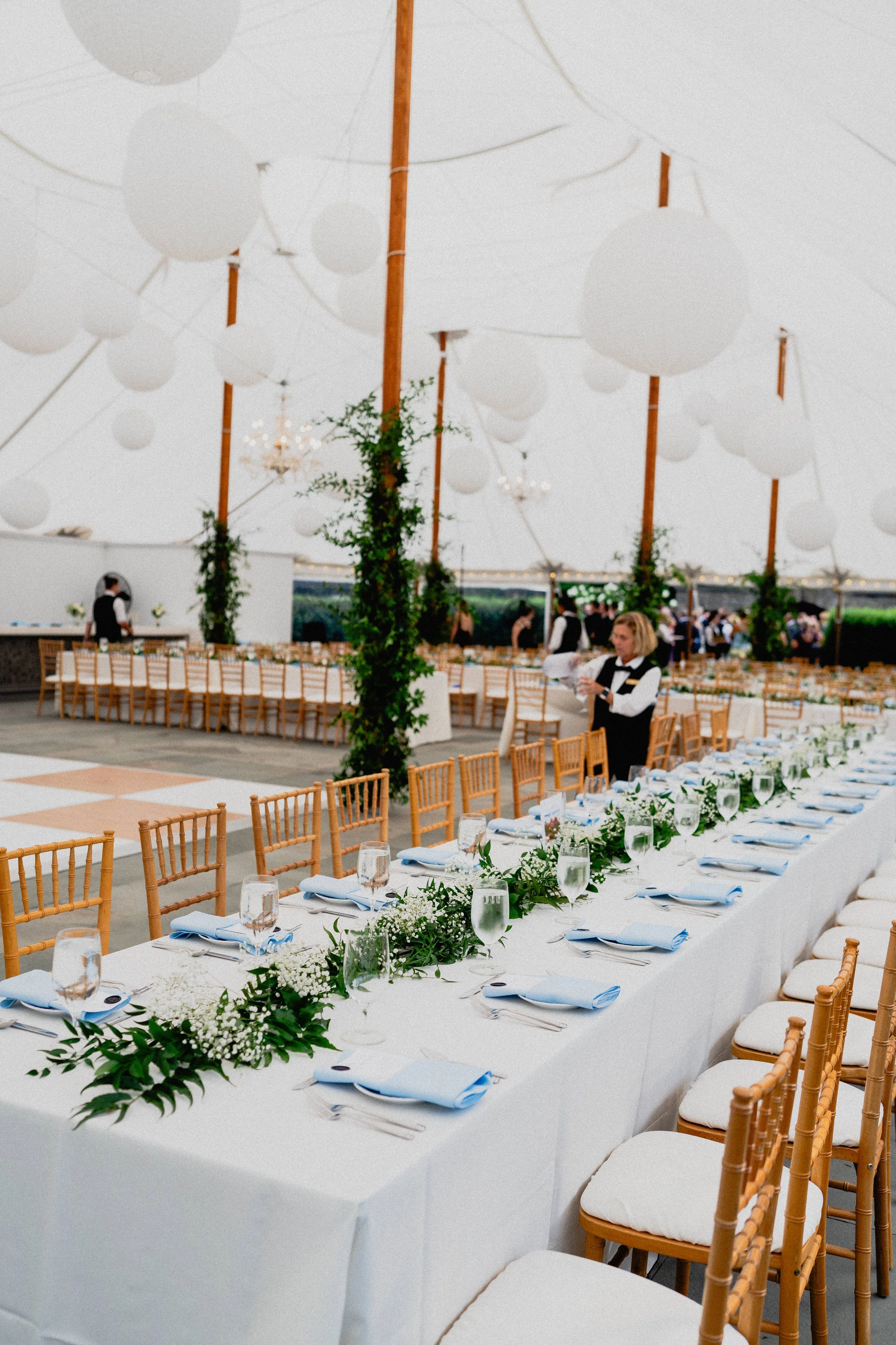 Luxury wedding photography detail of long reception tables with white flowers beneath a clear-top tent in Upstate New York.