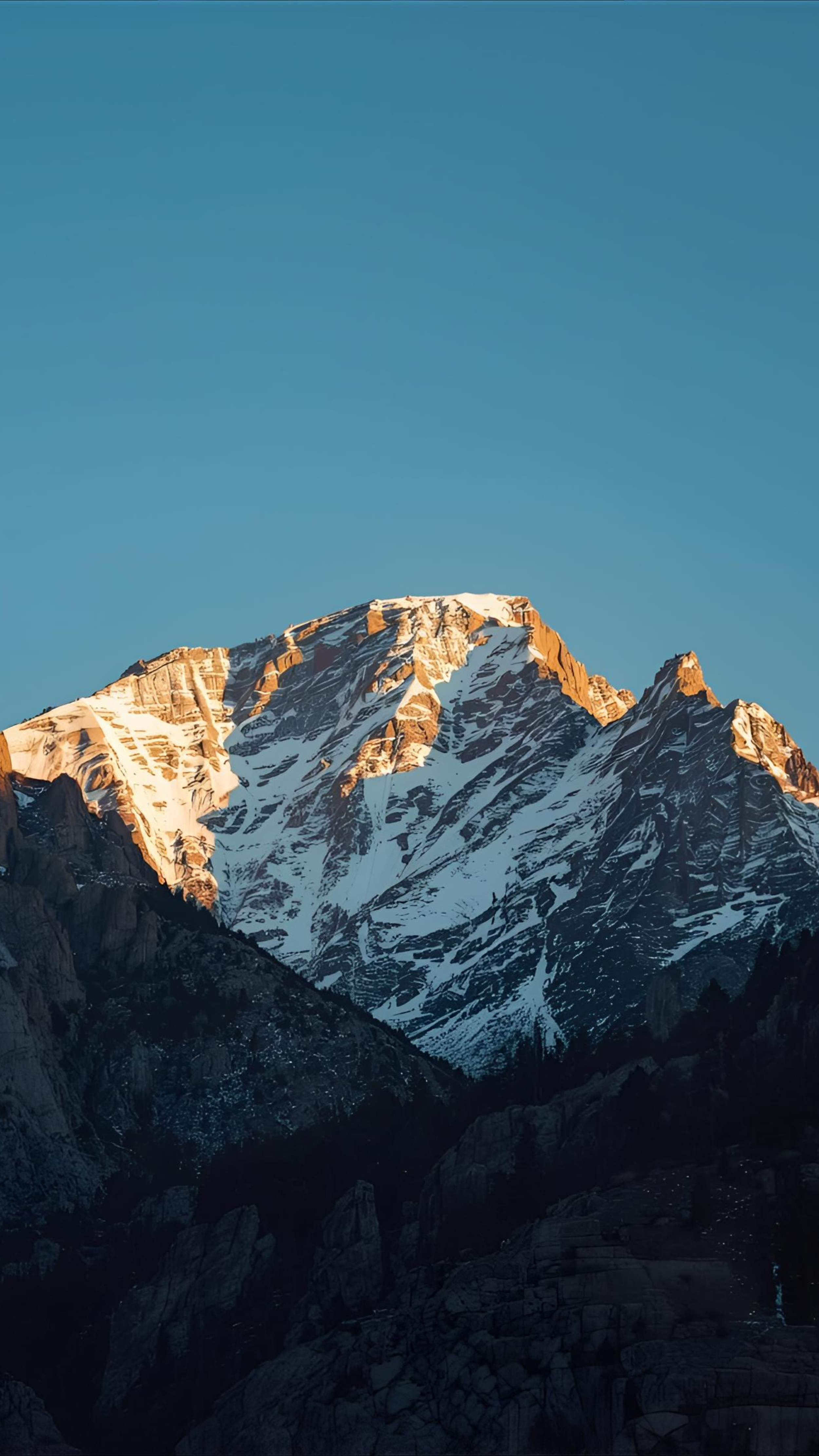 Snow-capped mountain peaks against a clear blue sky.