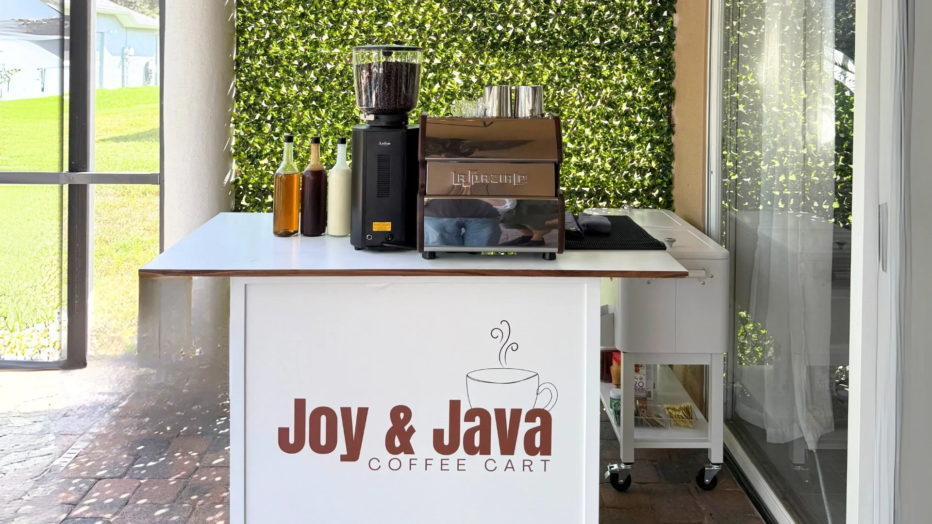 Custom coffee cart for catering with espresso machine coffee grinder custom cart sign and homemade coffee syrups.