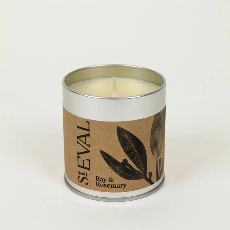 St. Eval Bay & Rosemary tin candle with kraft paper label and black leaf design, shown against a white background