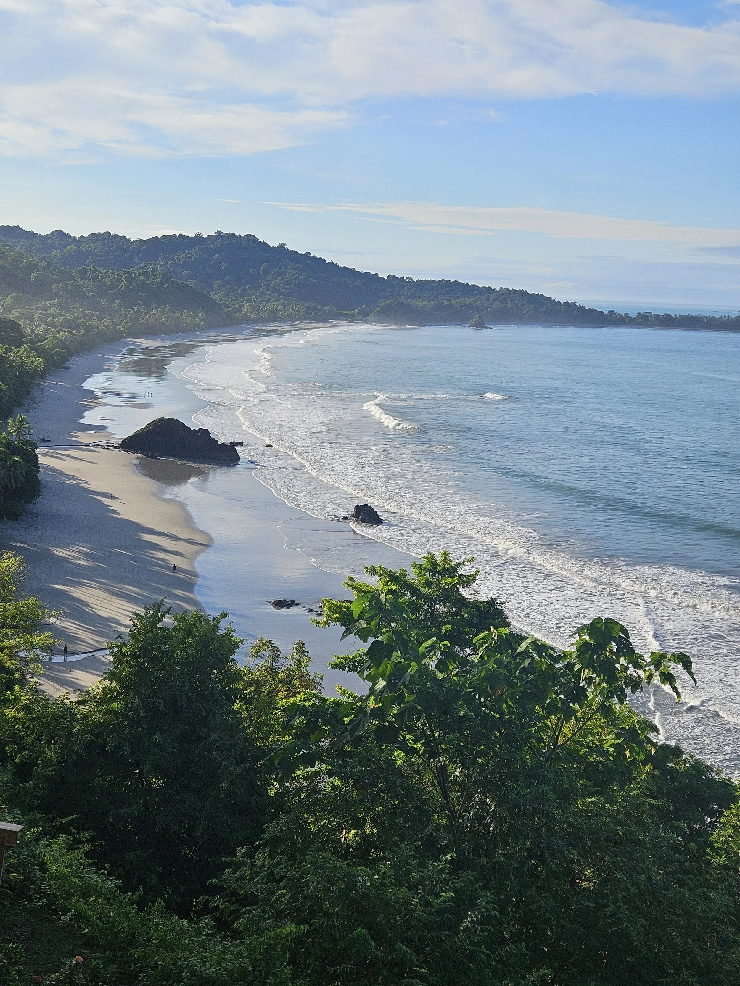 Secluded tropical beach with turquoise water and lush hillside, ideal for a luxury honeymoon or bespoke travel experience
