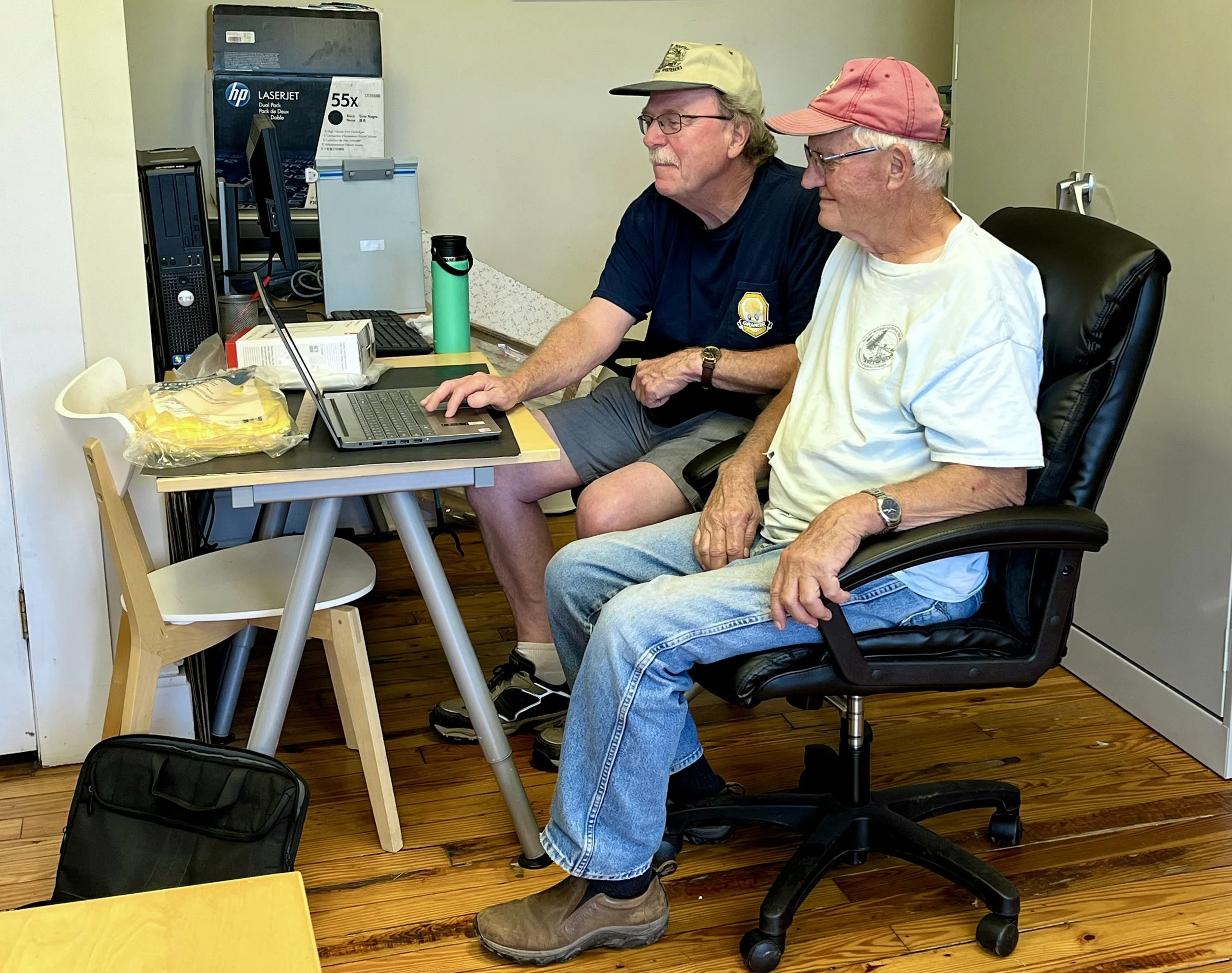 Two men sitting working on a laptop together in the Grant Computer Center.