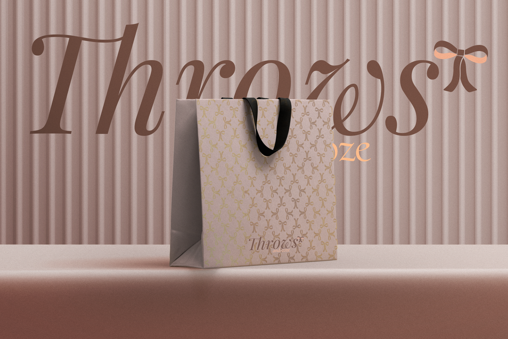 Throws & Coze shopping bags on a shelf against a soft pink wall.