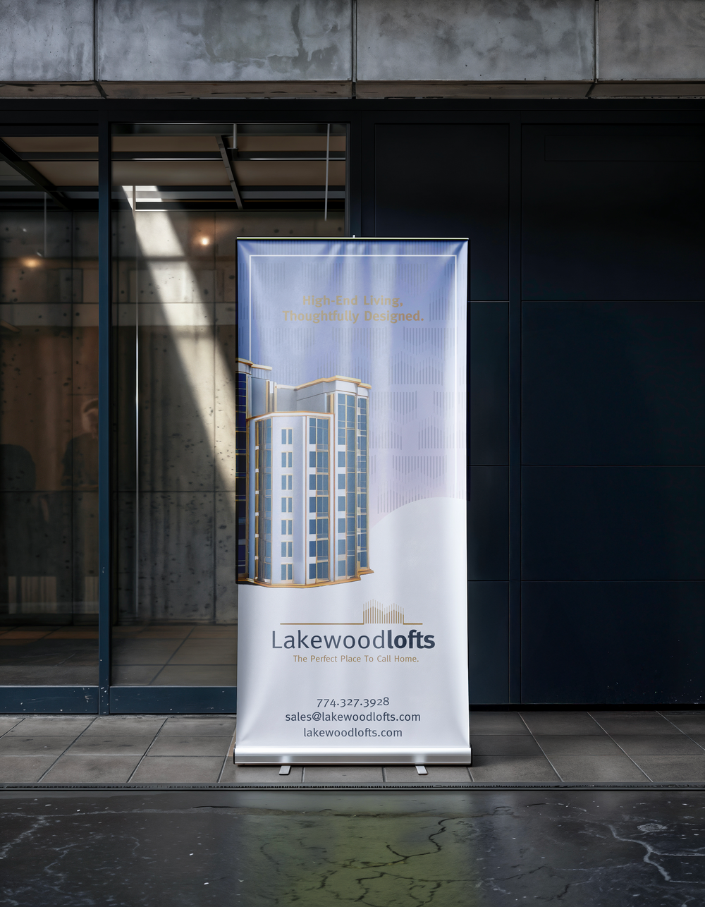 A vertical Lakewood Lofts banner outside a modern building: an illustrated high-rise and the line “High-End Living, Thoughtfully Designed.”