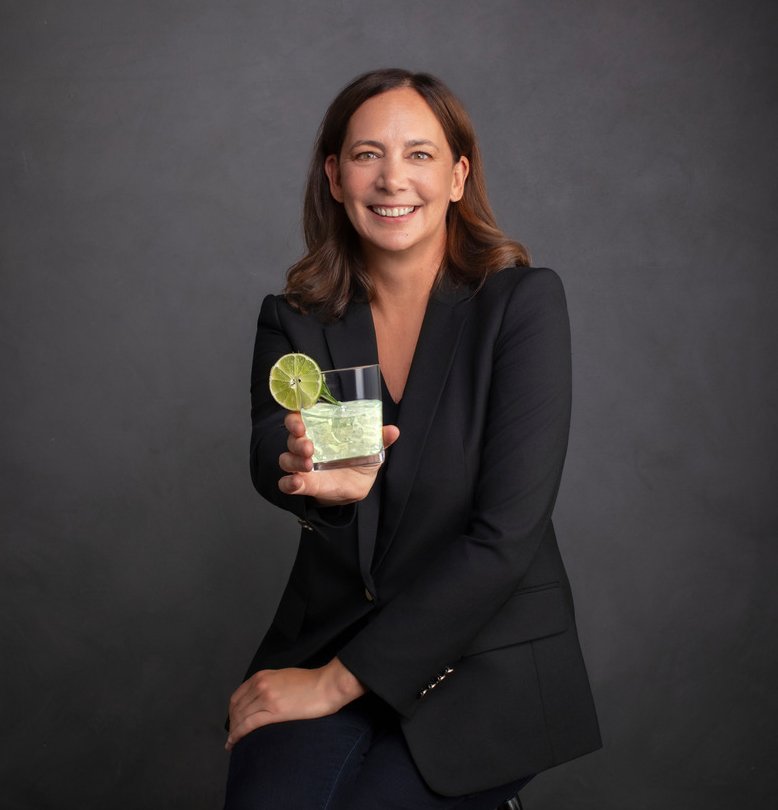 Tania Tomaszewska, co-founder of SideBar®, holding a glass of SideBar® Secret Cove Lime.