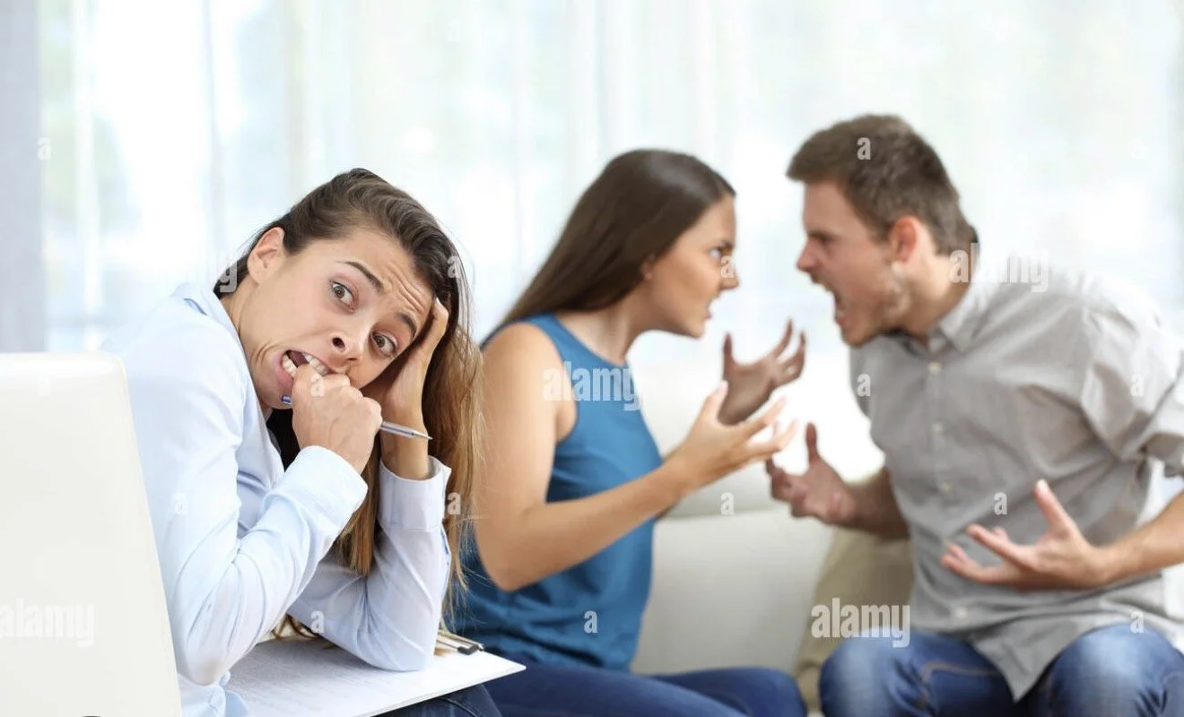 Sandy beach with sparse beach grass and footprints, overexposed bright sun in the sky.