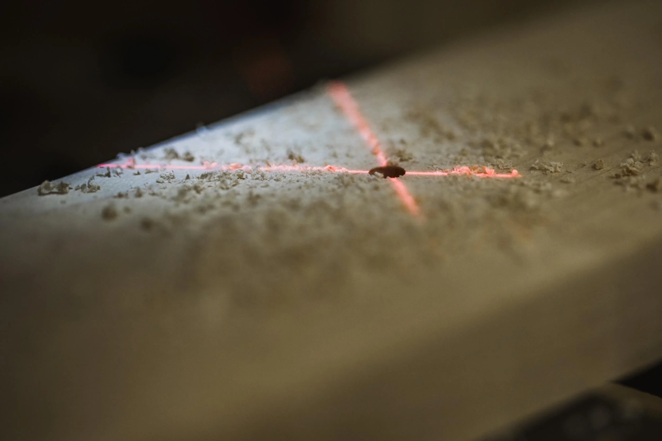 drill press laser on wood with drilled hole and saw dust