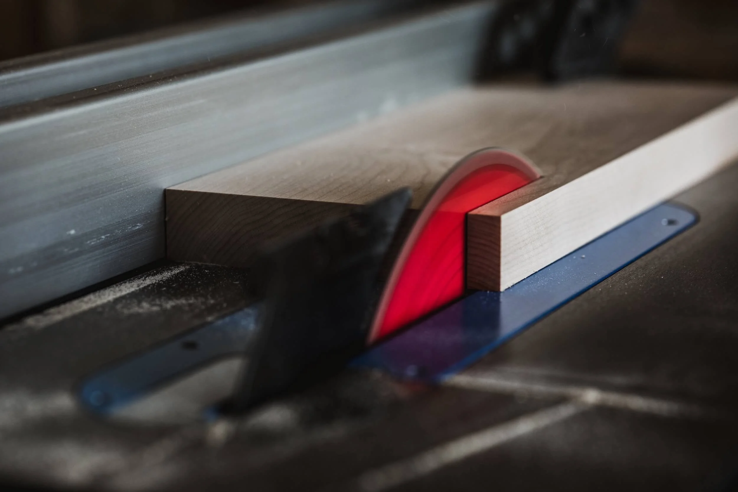 red circular table saw cutting plank of wood