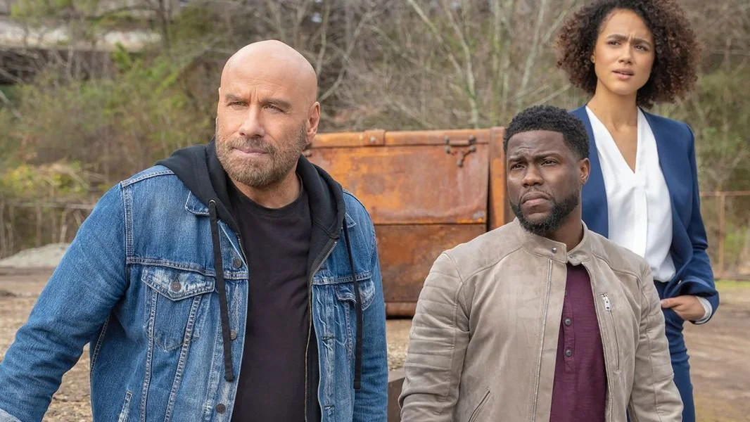 Still from the LOL Studios and Roku series Die Hart, starring John Travolta, Nathalie Emmanuel, and Kevin Hart