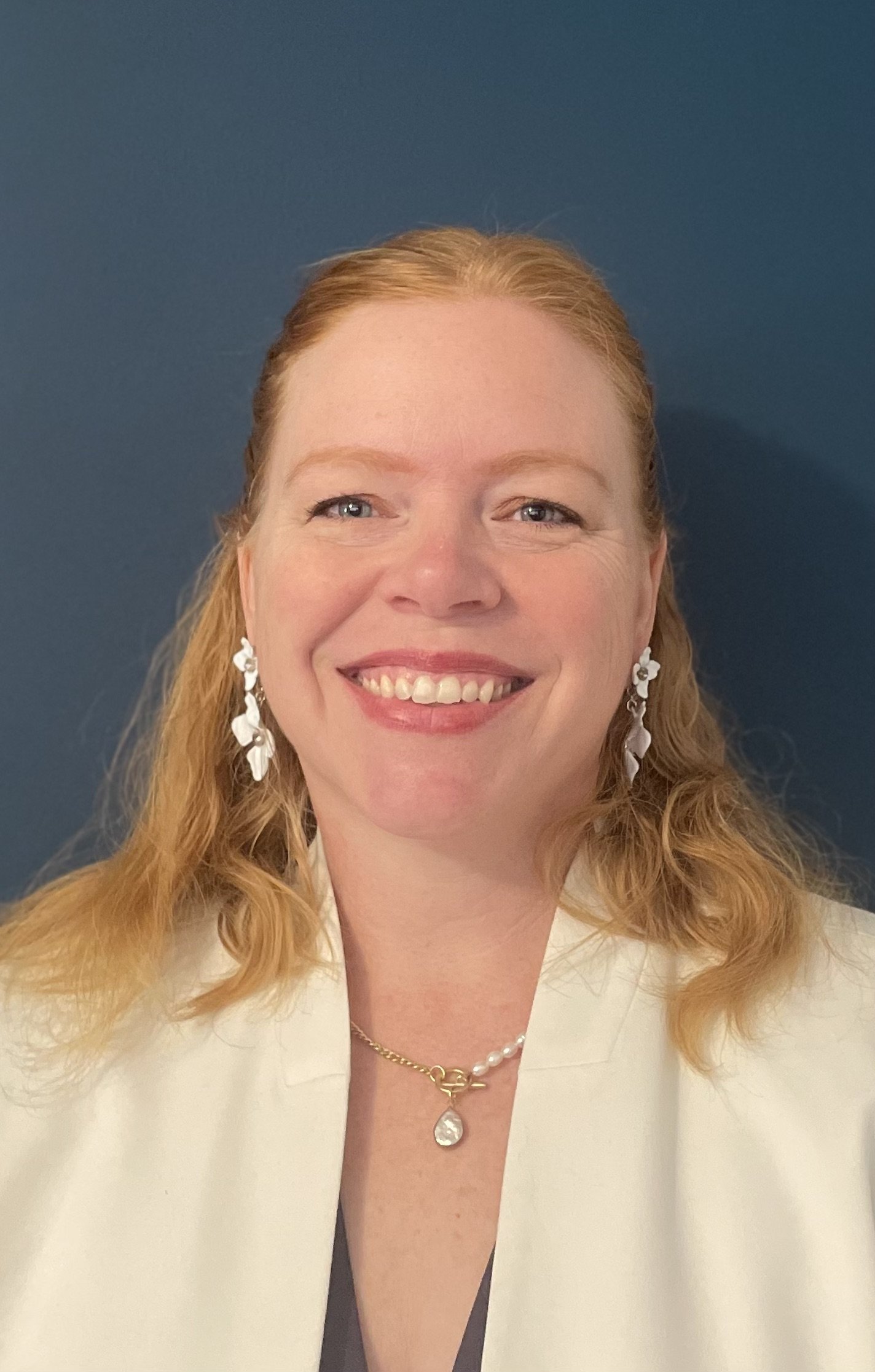 A smiling white woman in professional dress
