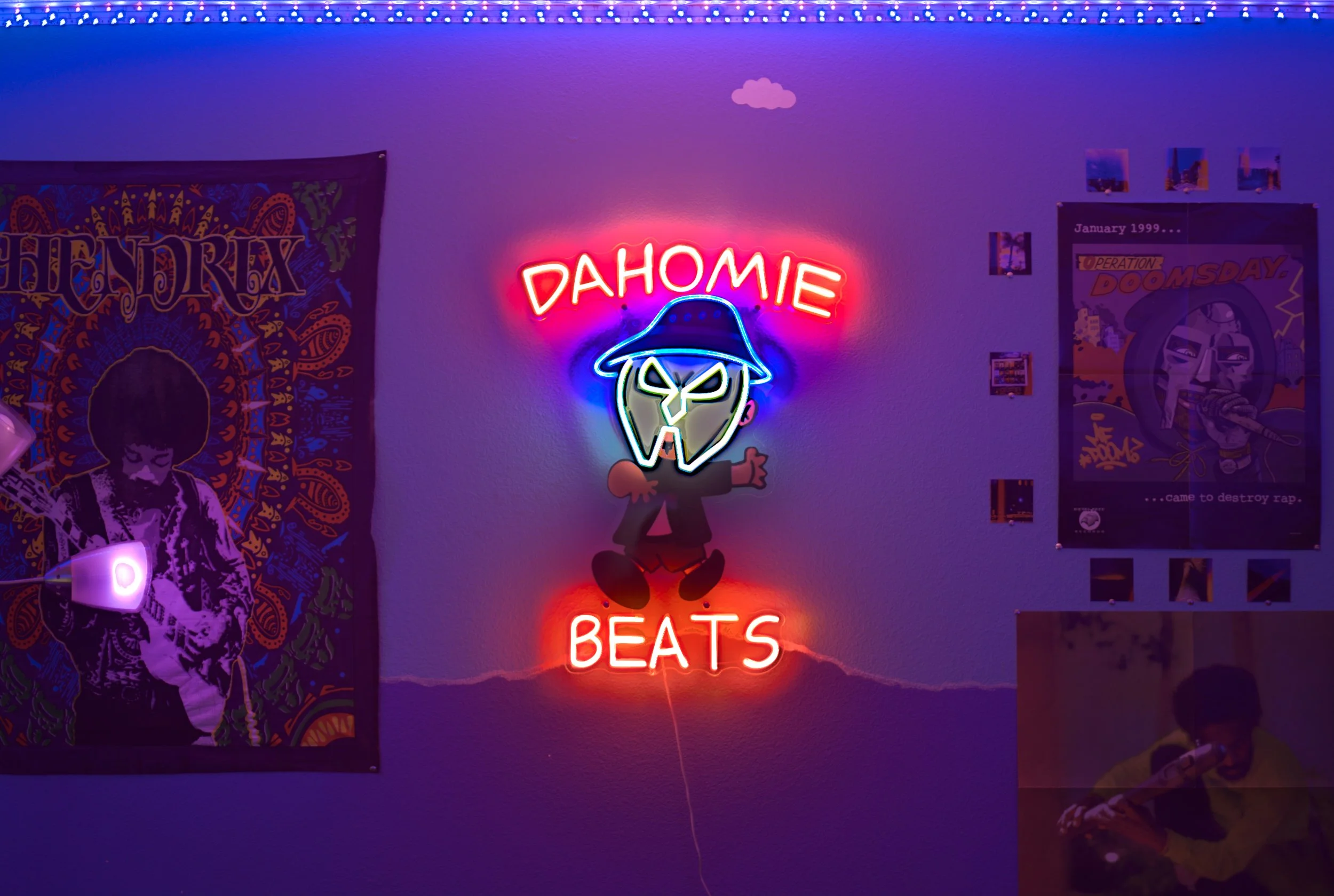Neon sign on wall with words 'Dahomie Beats' and a cartoon character wearing a hat.