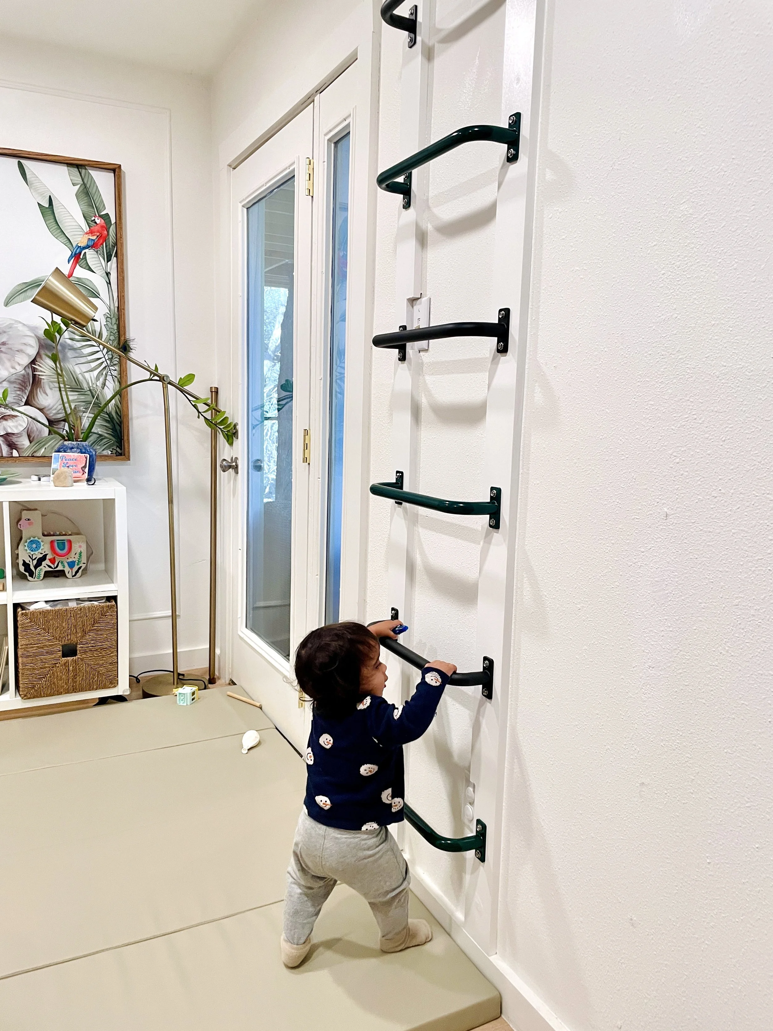 Baby attempts to climb monkey bars