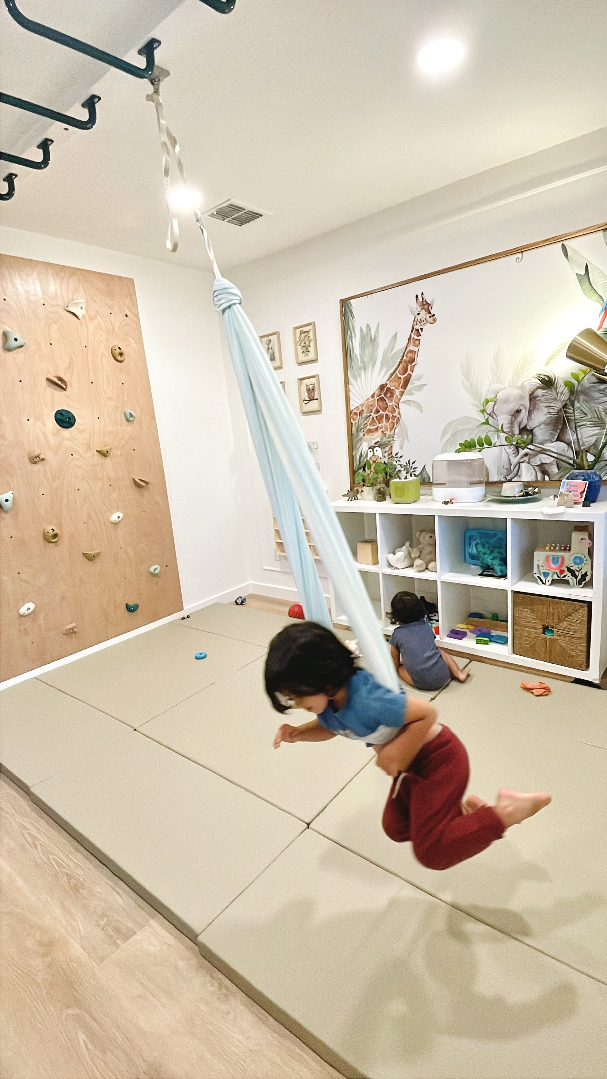 Toddler swings wildly while baby plays on mat