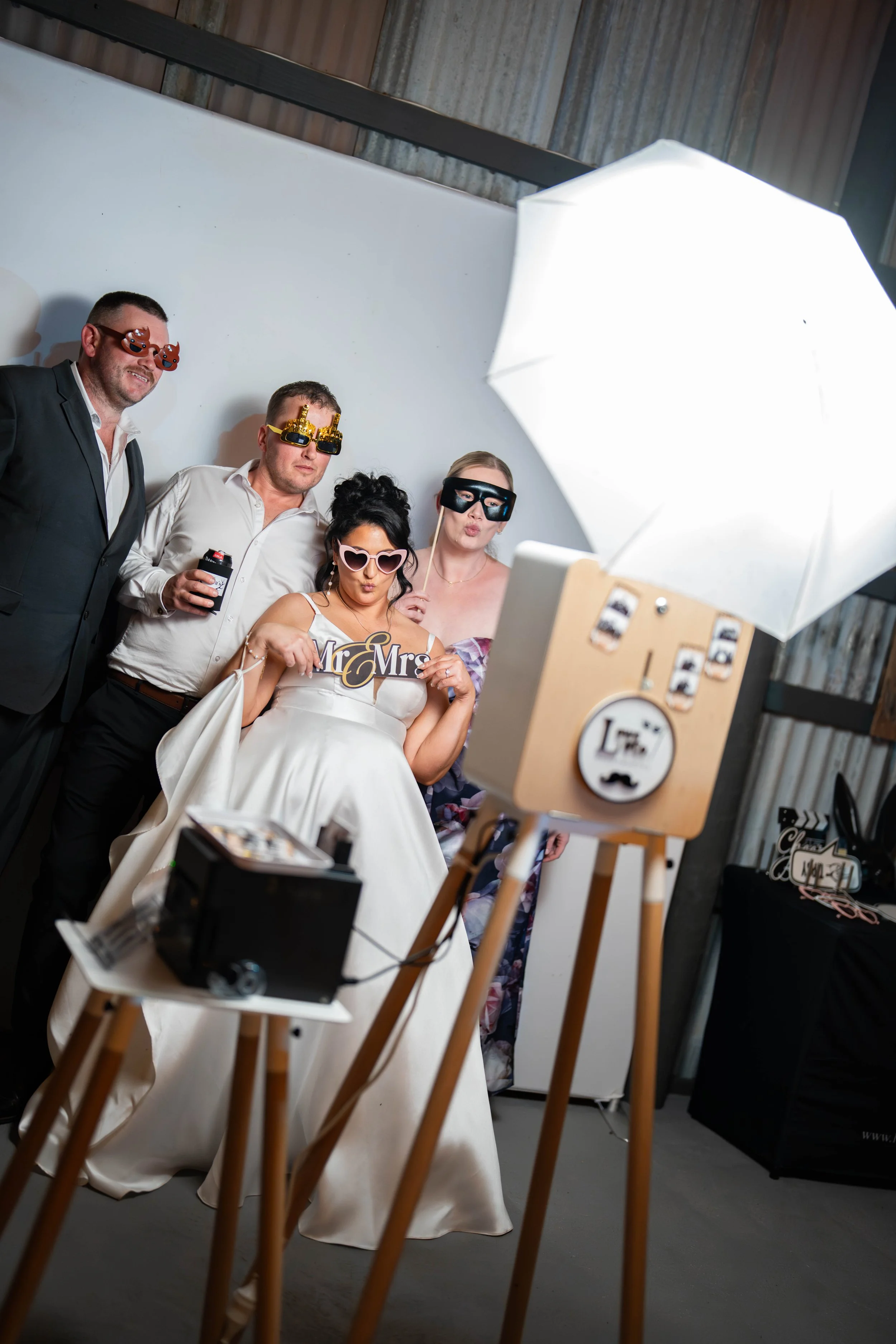 Bride laughing while guests use photo booth at Melbourne wedding