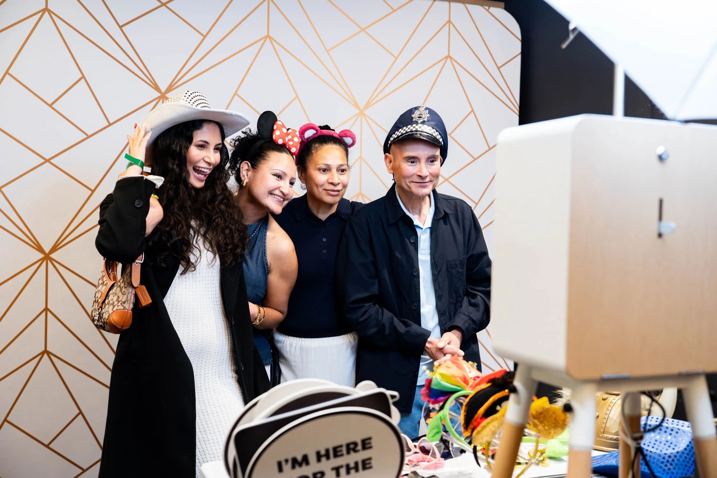 group of guests inside the booth, using props smiling, celebrating a 16th birthday party