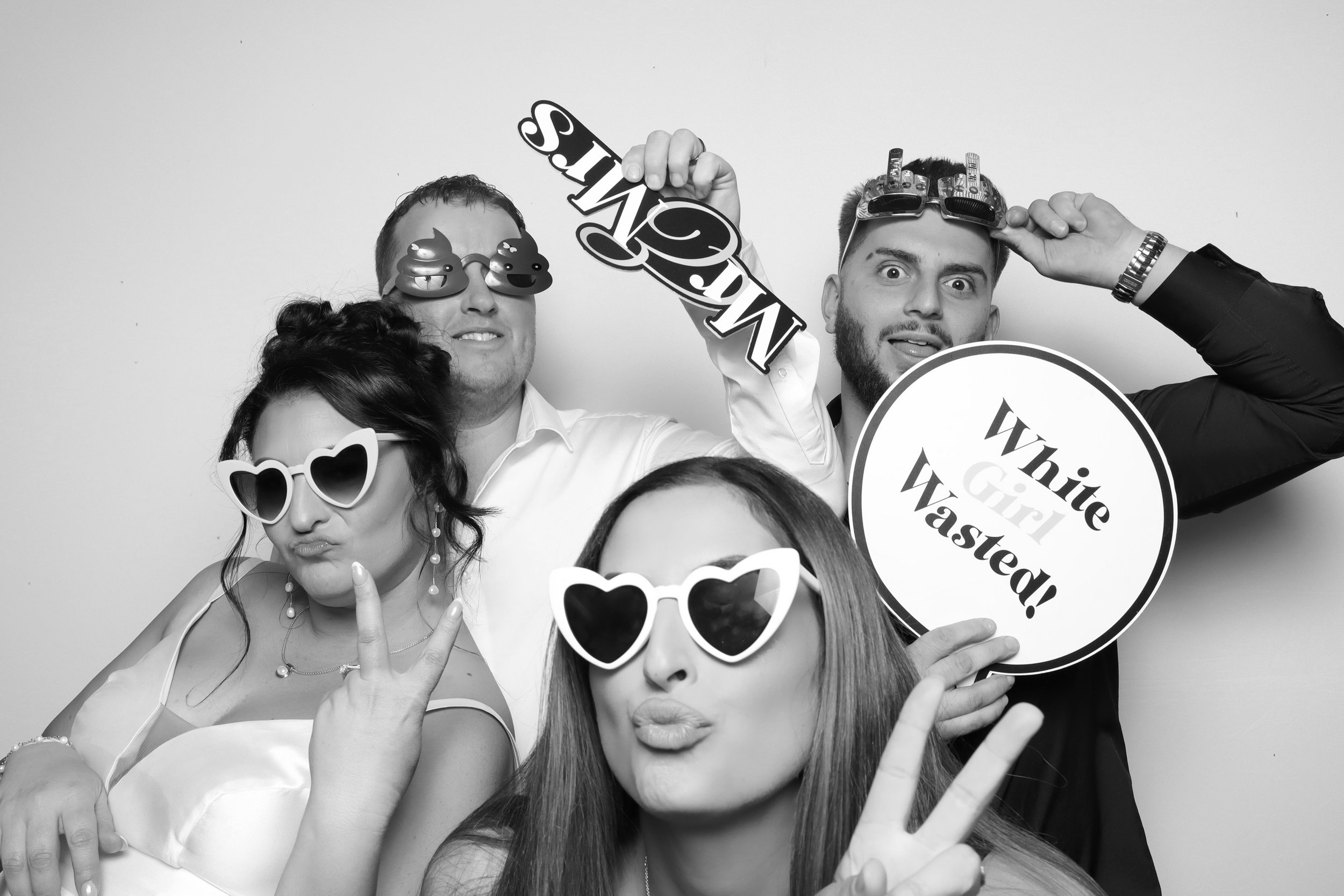 Groom and groomsmen with guests pulling faces in black and white wedding photo booth Melbourne