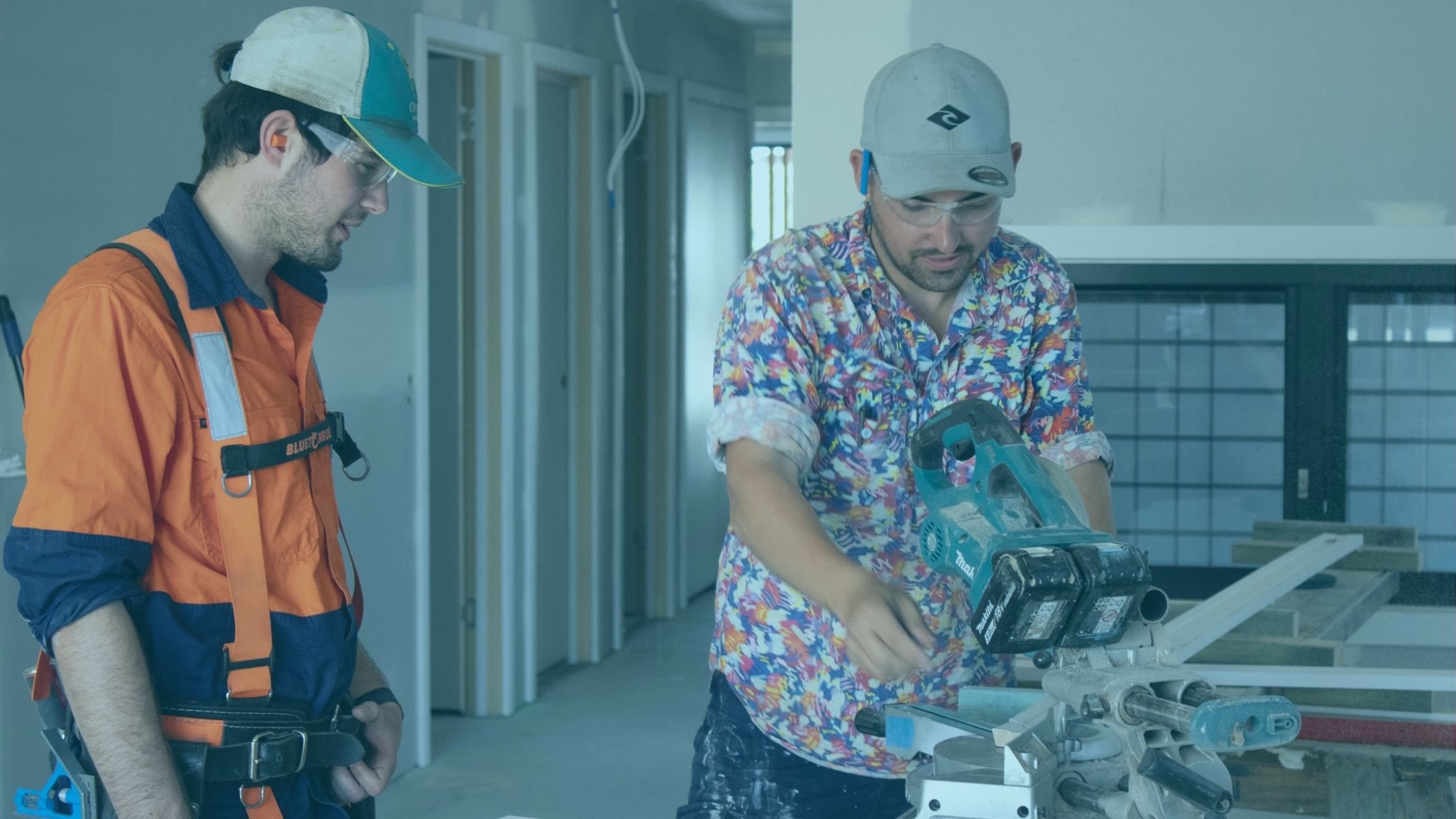 Carpenter passing on his knowledge to an apprentice