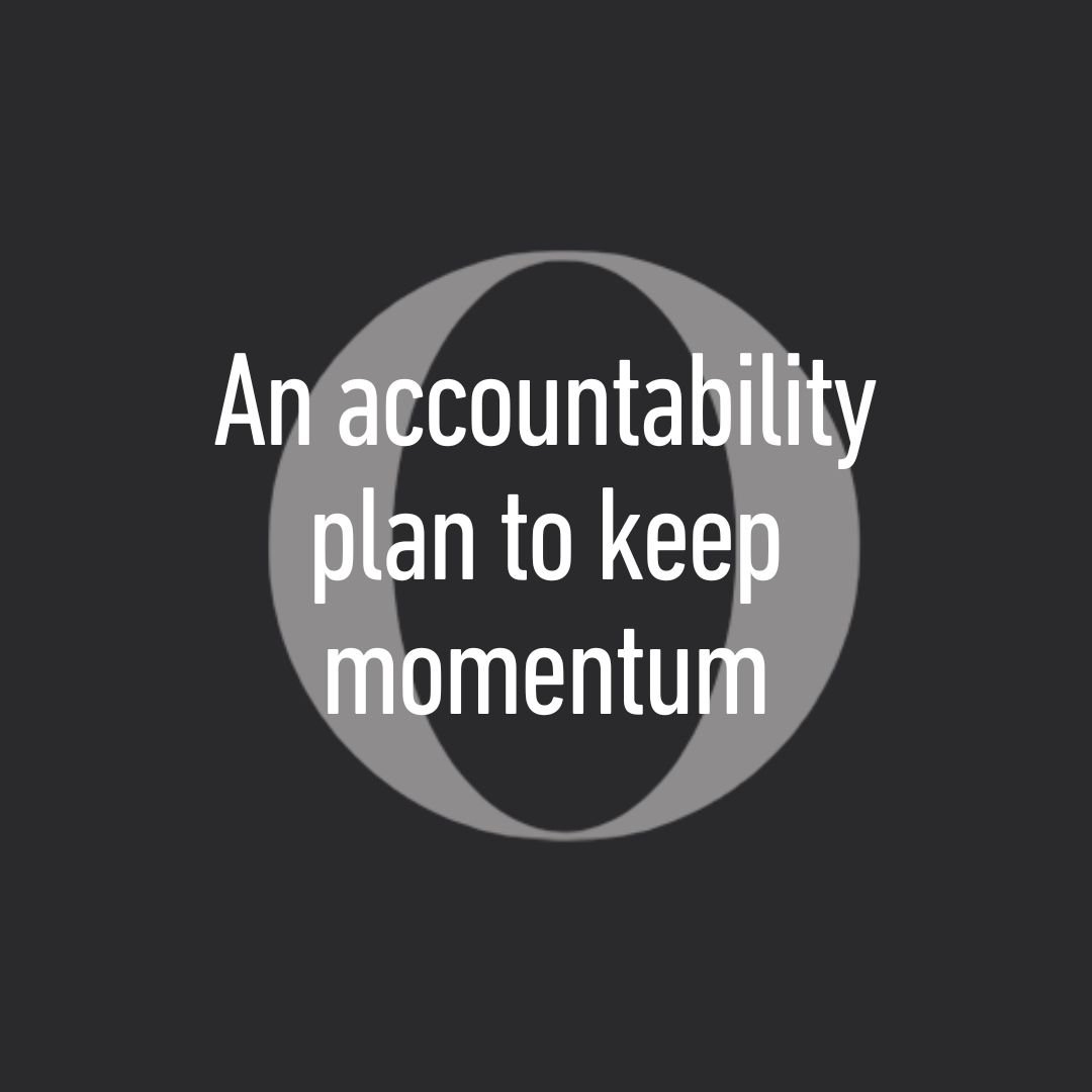 A circular symbol with a dark background and grey outline, featuring the text 'An accountability plan to keep momentum' in white font.