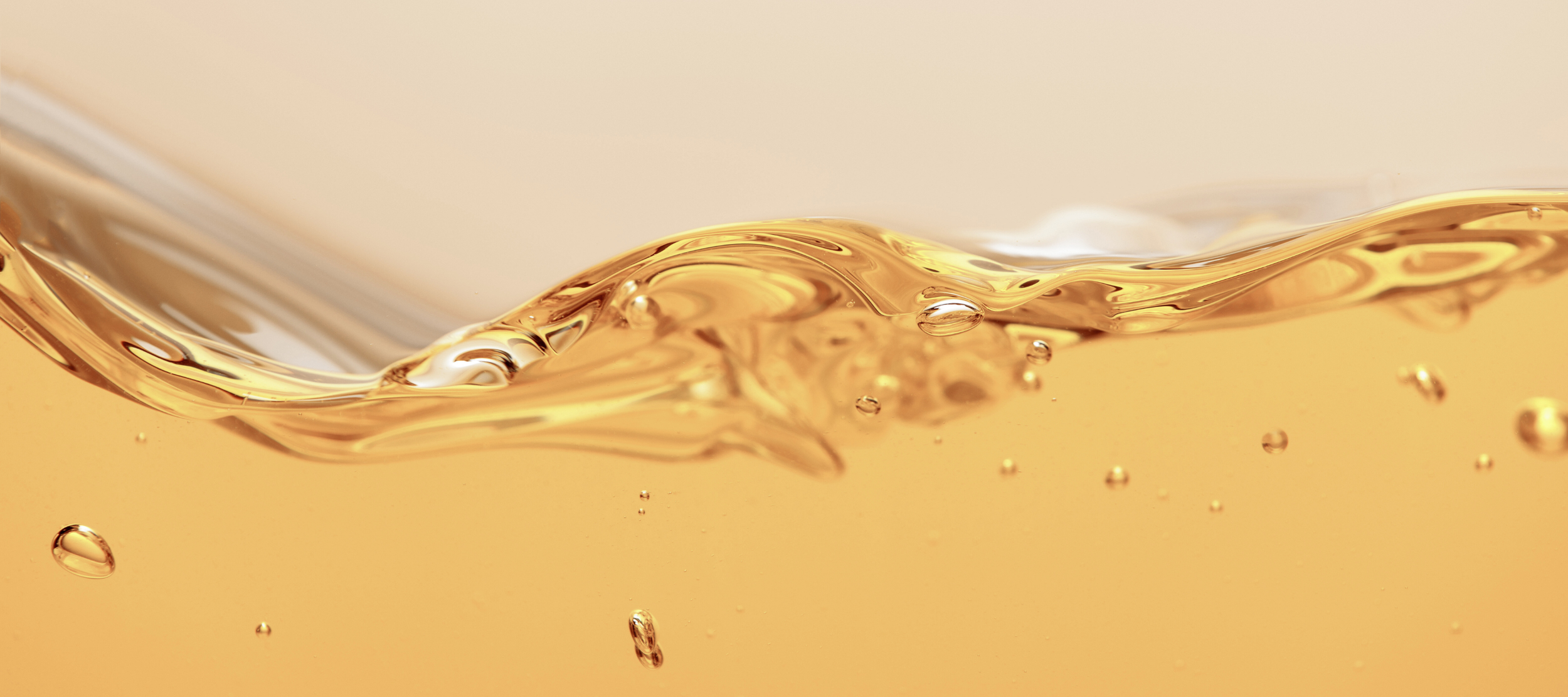 Liquid in motion with a smooth wave crest and small suspended bubbles.