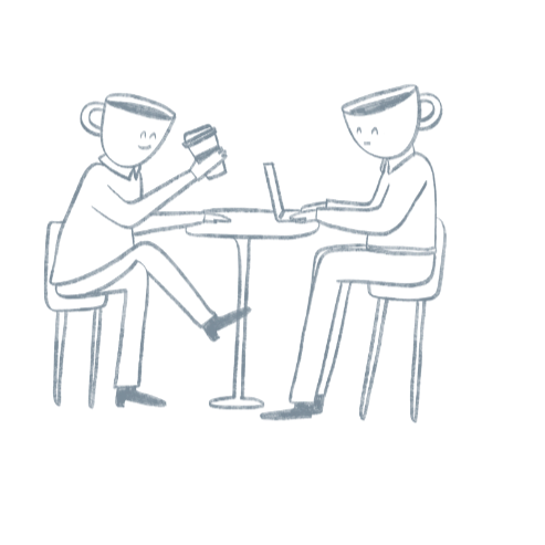 Two people with coffee cups sitting at a table, one using a laptop.