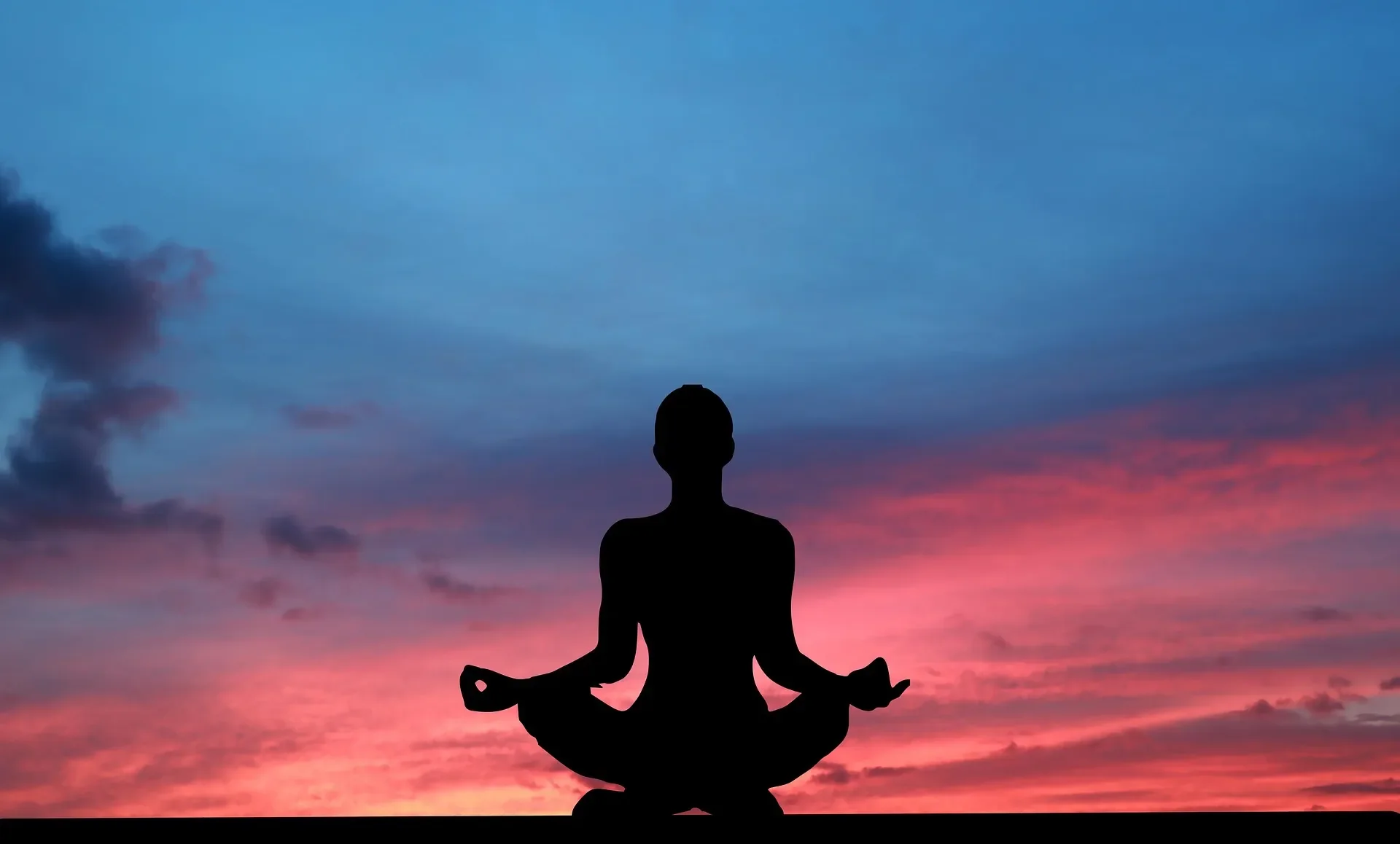 Silhouette of person meditating at sunset symbolizing the relaxing, restorative effects of hydrodermabrasion