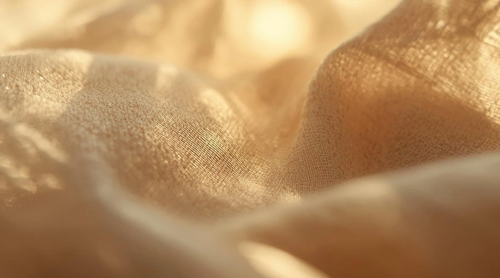 Close-up of a textured, golden fabric with soft lighting highlighting its woven pattern.