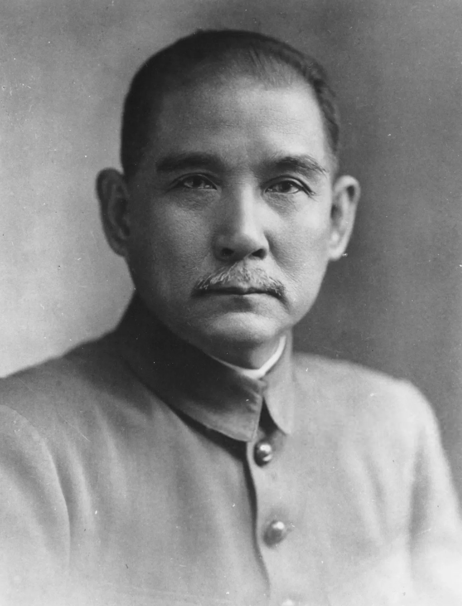 Historical black and white portrait of Sun Yat-sen in a military uniform with a mustache, serious expression, and short, combed hair.