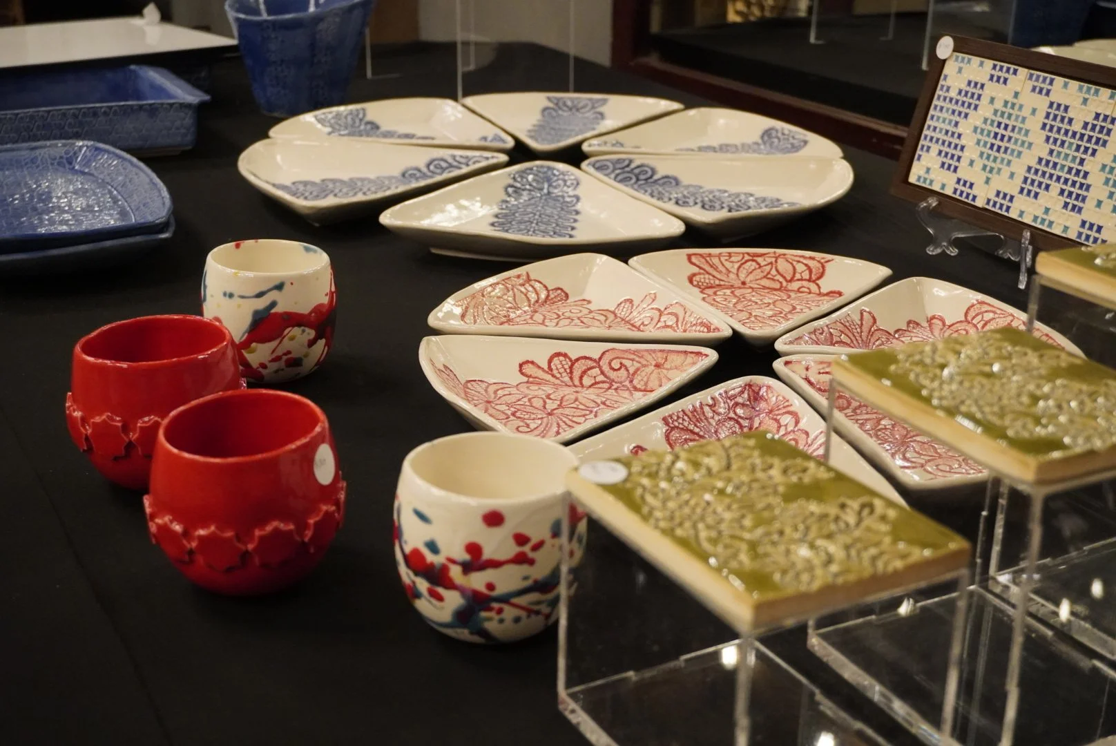 Tiles by Kuwaiti ceramicist and visual artist Najla Alradwan. 13 tiles shown with Middle Eastern-inspired designs and shapes.