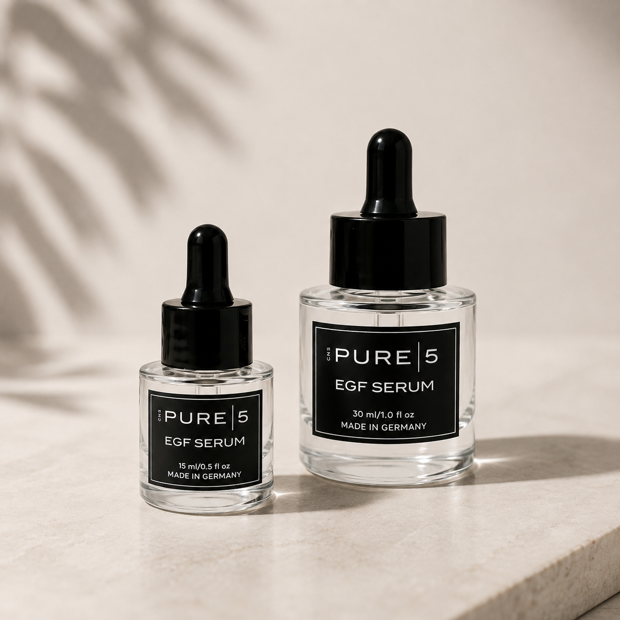 Zwei Flaschen mit PURE 5 EGF Serum, eine kleine und eine große, auf einer hellen Oberfläche, mit einem Schatten im Hintergrund.
