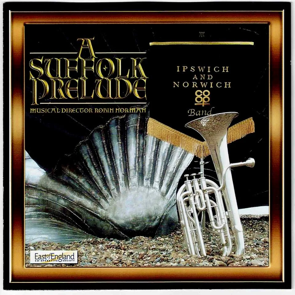 Poster for a musical titled 'A Suffolk Prelure,' directed by Robin Norman, featuring a brass instrument and a sculpture of a ship's prow, with event details for Ipswich and Norwich by East of England Cooperative Society.