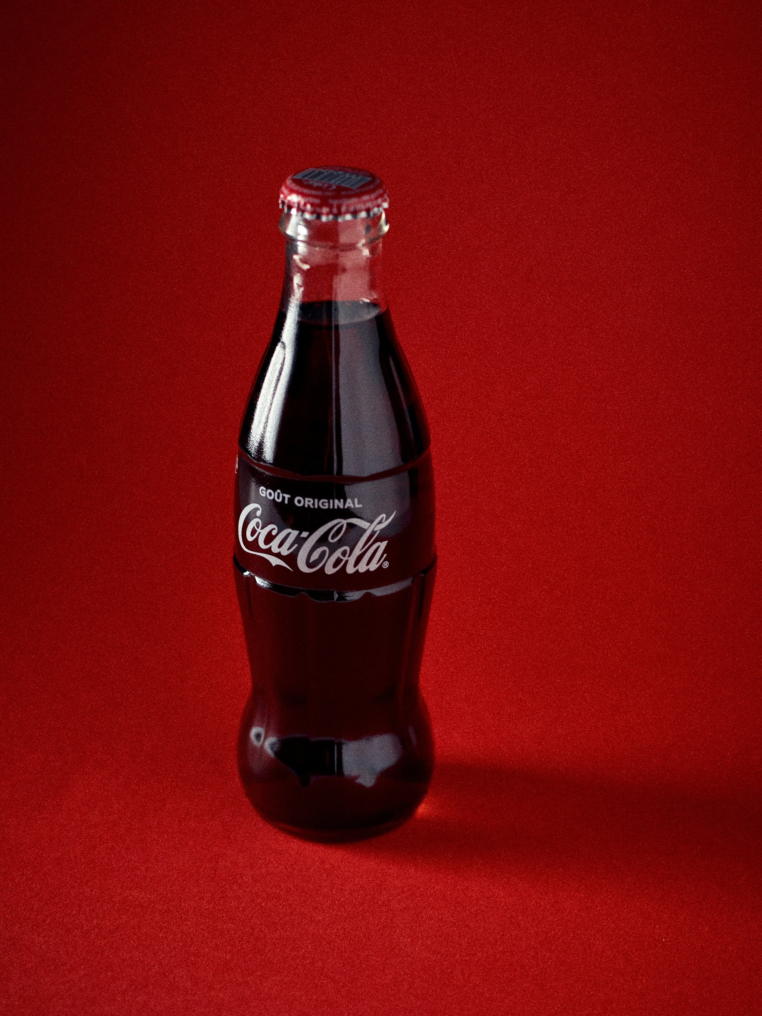 Bouteille de Coca-Cola originale sur un fond rouge photographié par un photographe spécialisé packshots à Lille