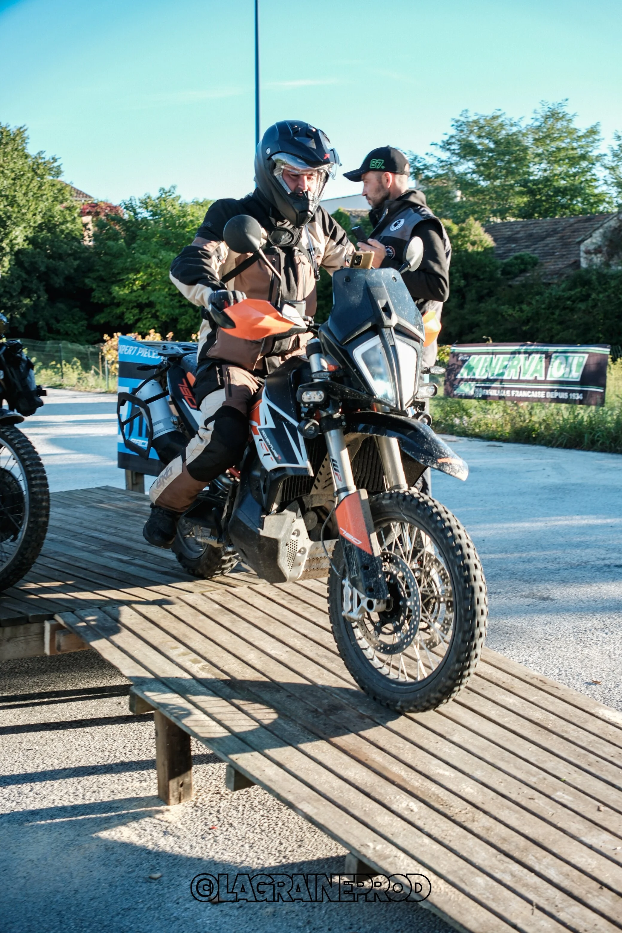 Motard en équipement de protection monte sur une moto tout-terrain en bois.