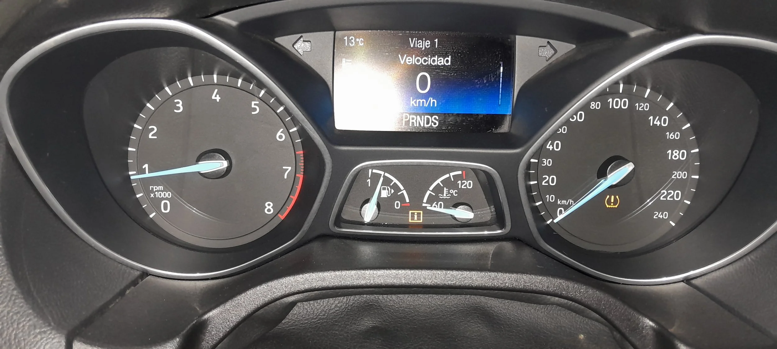 Tablero de coche con velocímetro, tacómetro y display digital mostrando 0 km/h y 13°C.