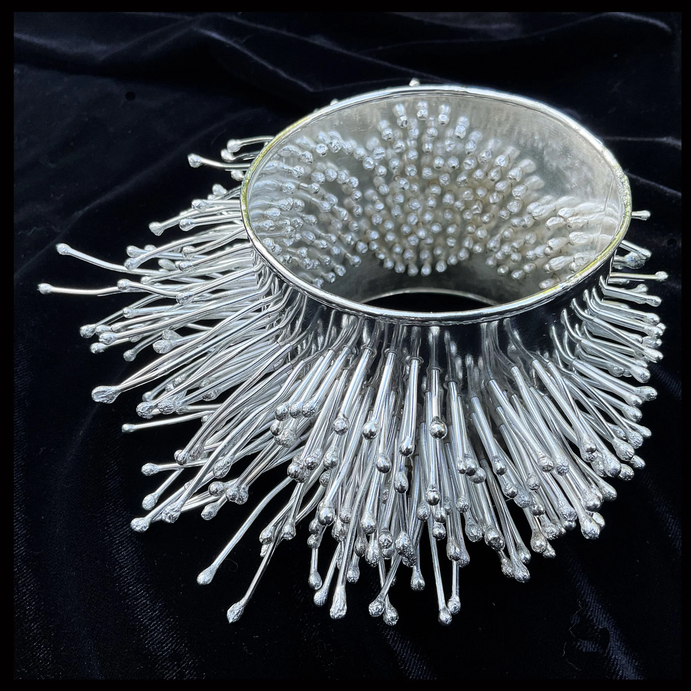 A sterling kinetic bangle bracelet that traps the wearer