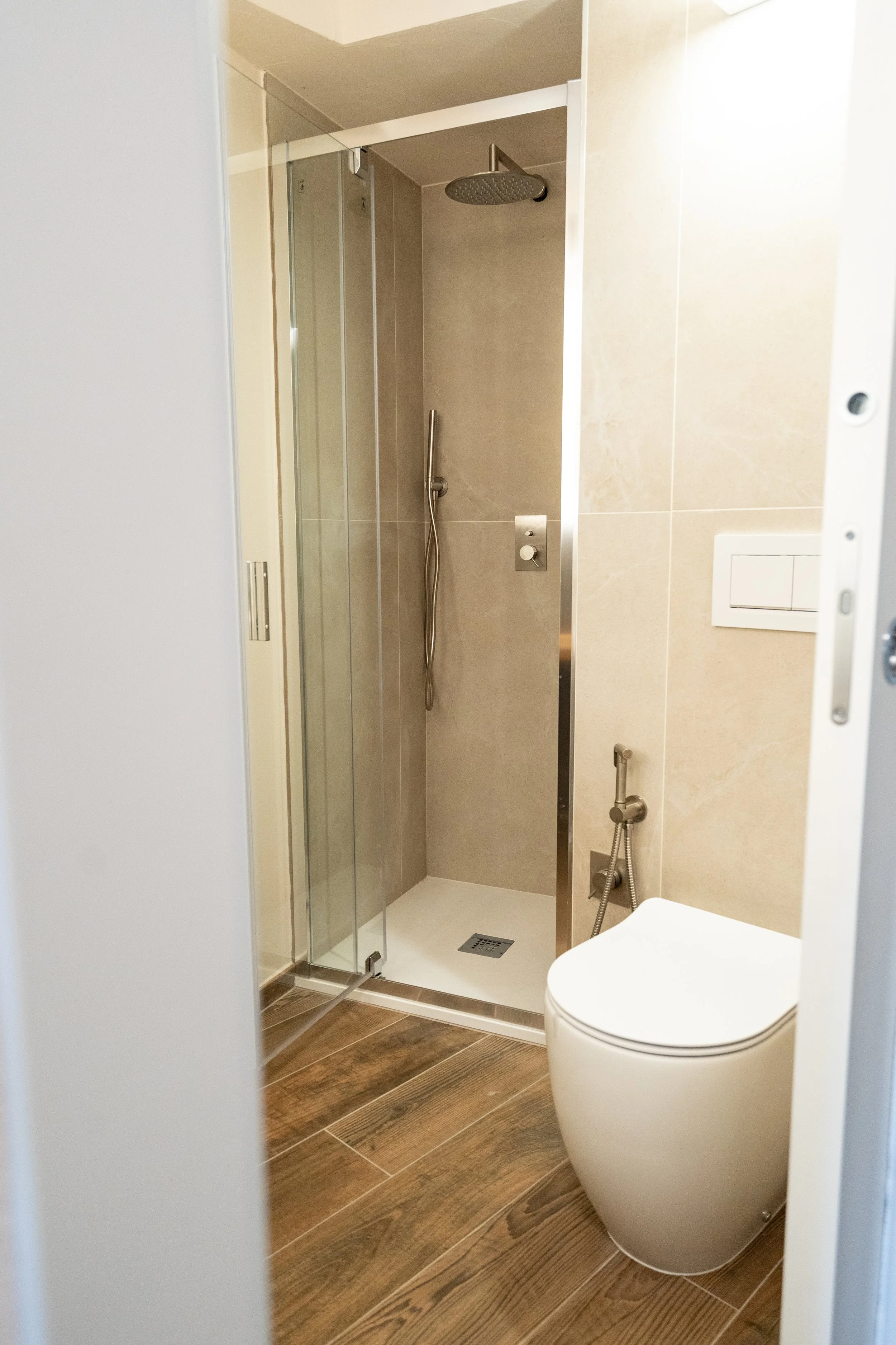 Piccolo bagno con doccia, WC e pavimento in parquet  - Residenze Volpigiano