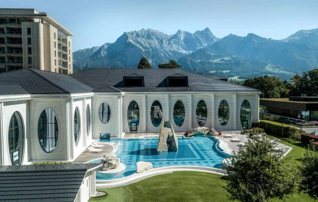 Luxury house with a backyard pool and mountain view in the background.