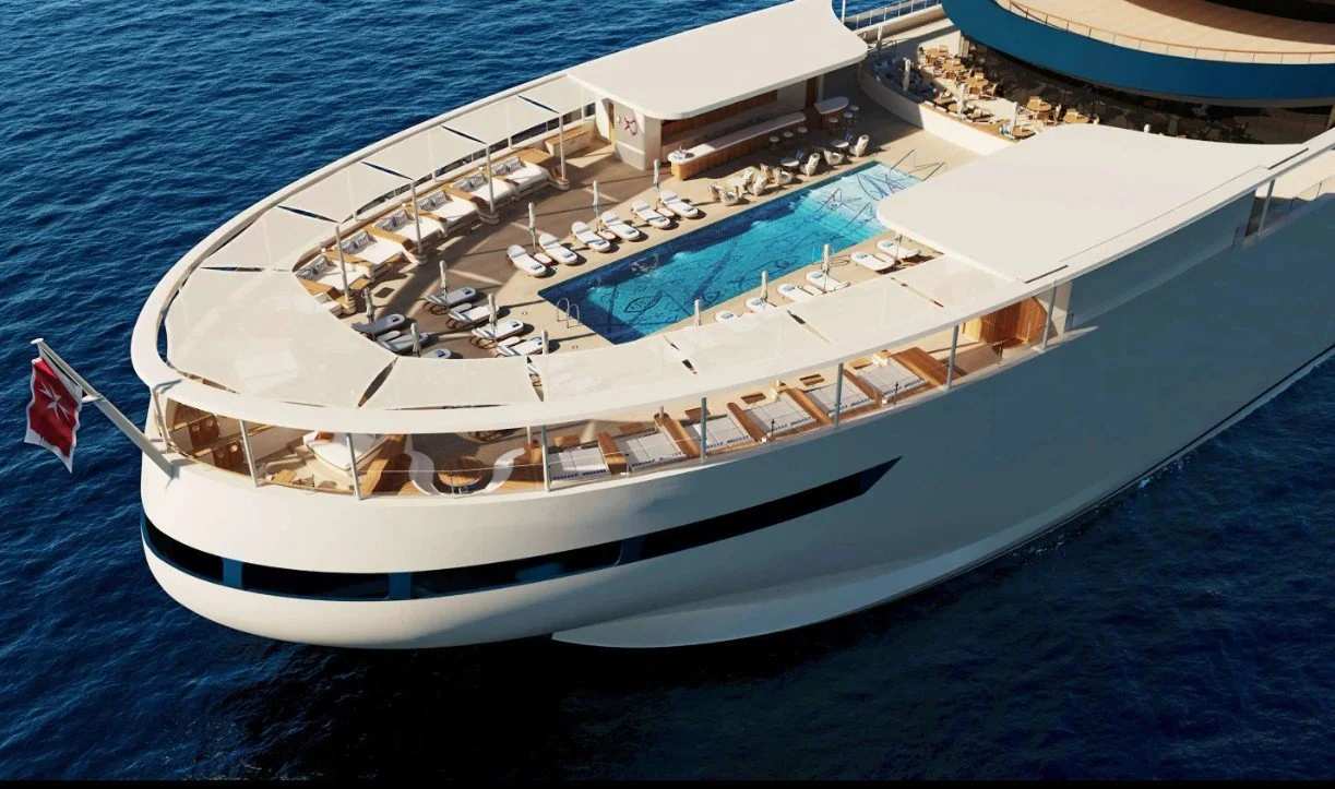 A luxury cruise ship with a rooftop swimming pool and sun loungers, sailing in the ocean.