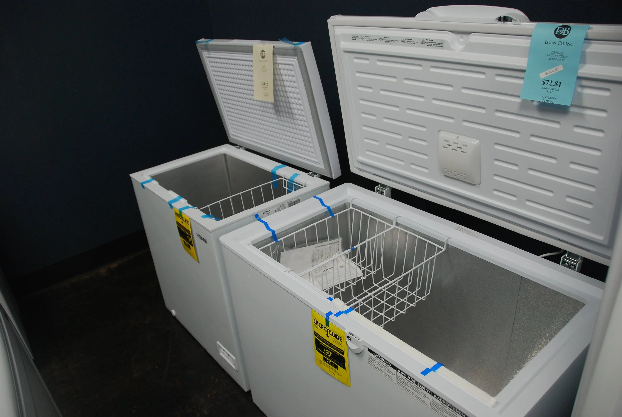 Empty white mini fridge with open door showing wire shelves and door compartments in a laundry room or kitchen.