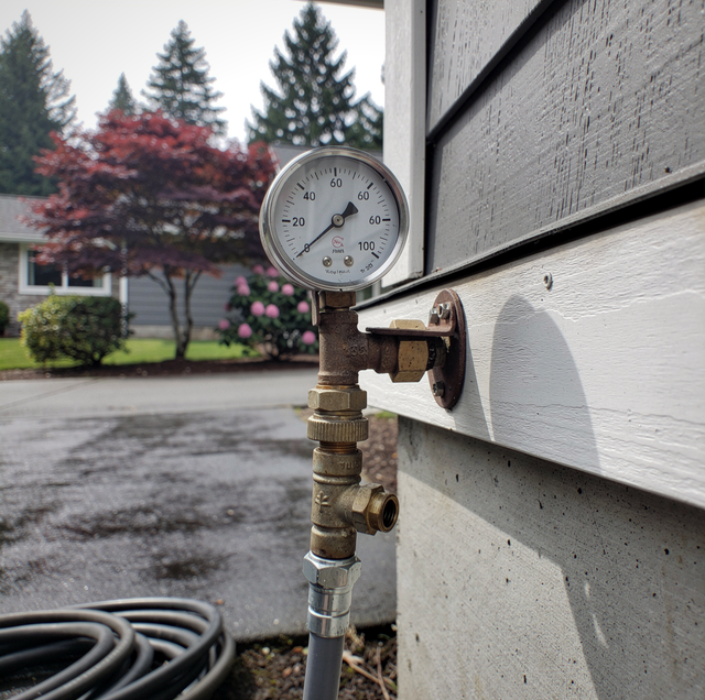brass pressure gauge attached to copper piping