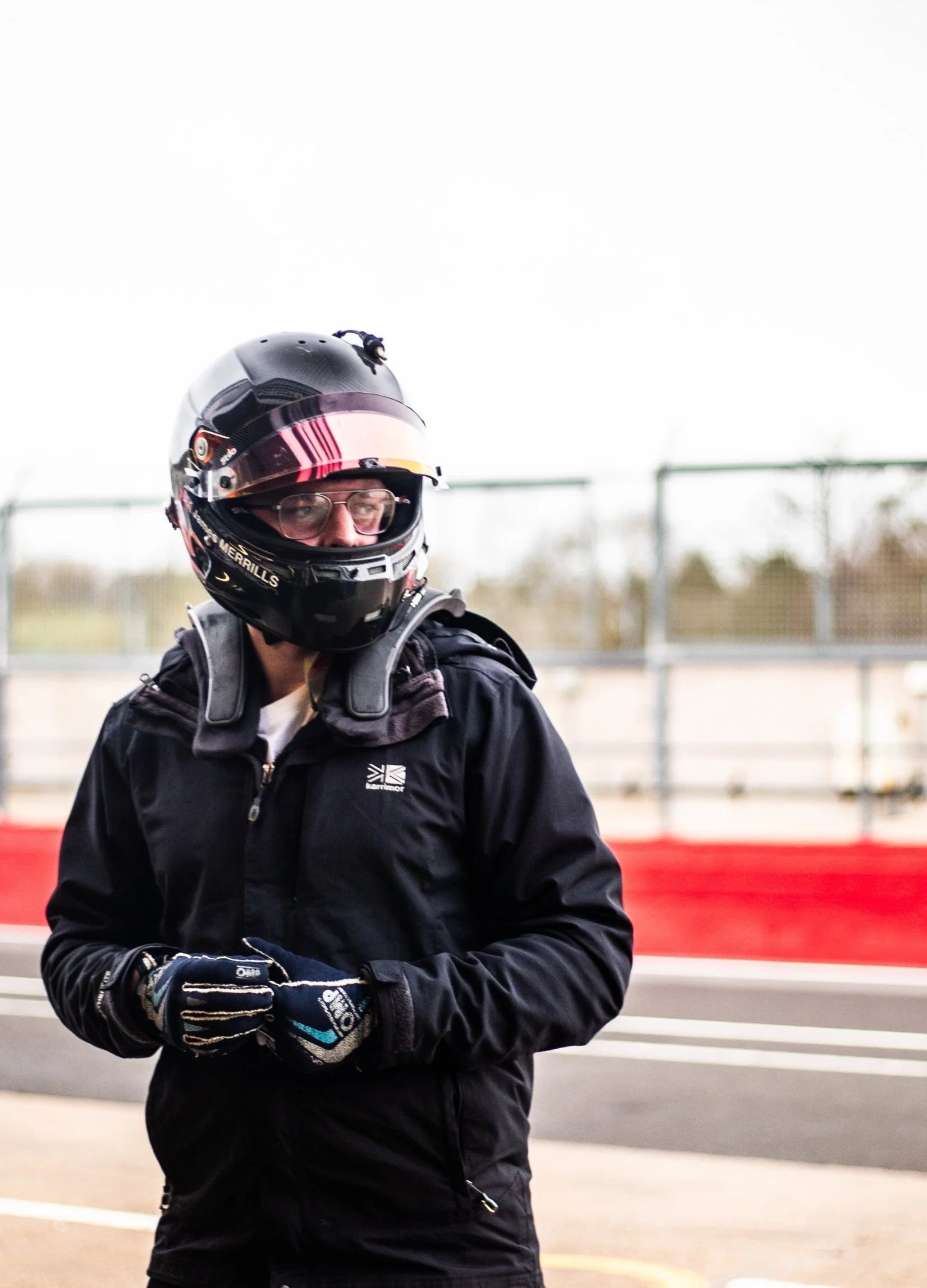 Racing driver with a helmet on that says James MERRILLS