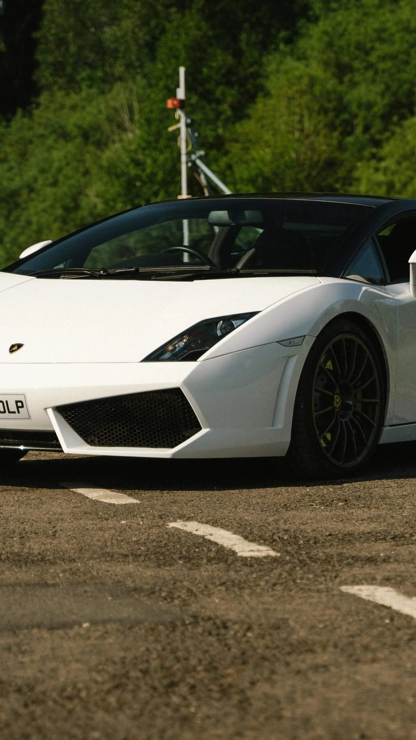 A white Lamborghini Gallardo parked up in the Curborough Sprint Course paddock, on a sunny day during a driving experience/track day
