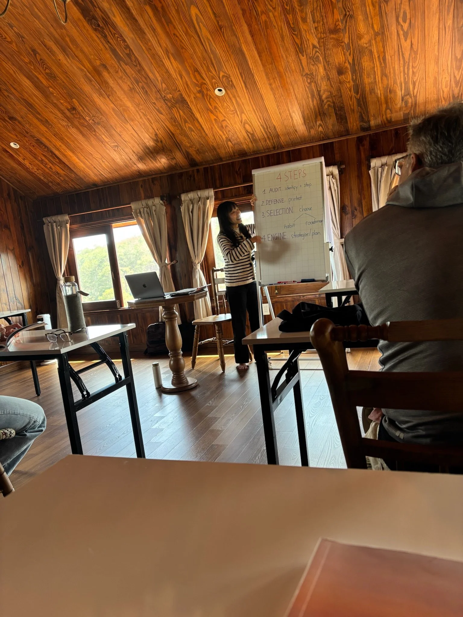 A person walking down a bamboo corridor with an arched bamboo roof, surrounded by tall bamboo stalks and greenery.