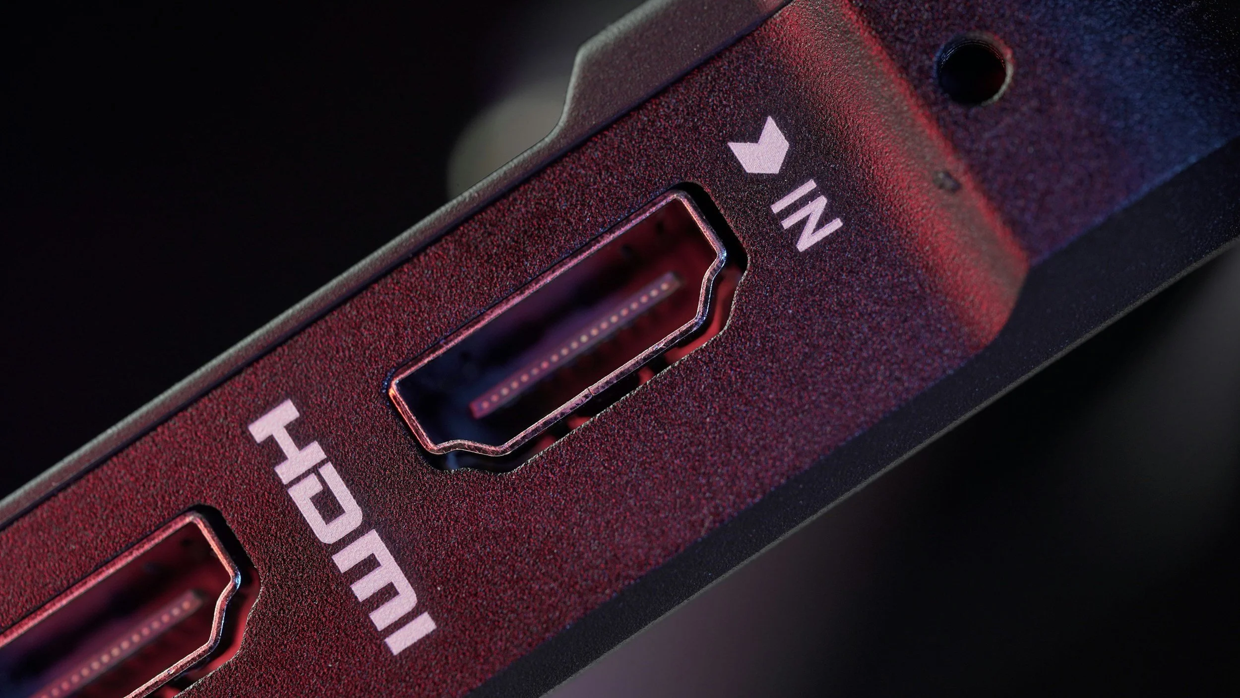 Close-up of a red power strip with two power outlets and an on/off switch labeled 'IN' with an upward arrow.